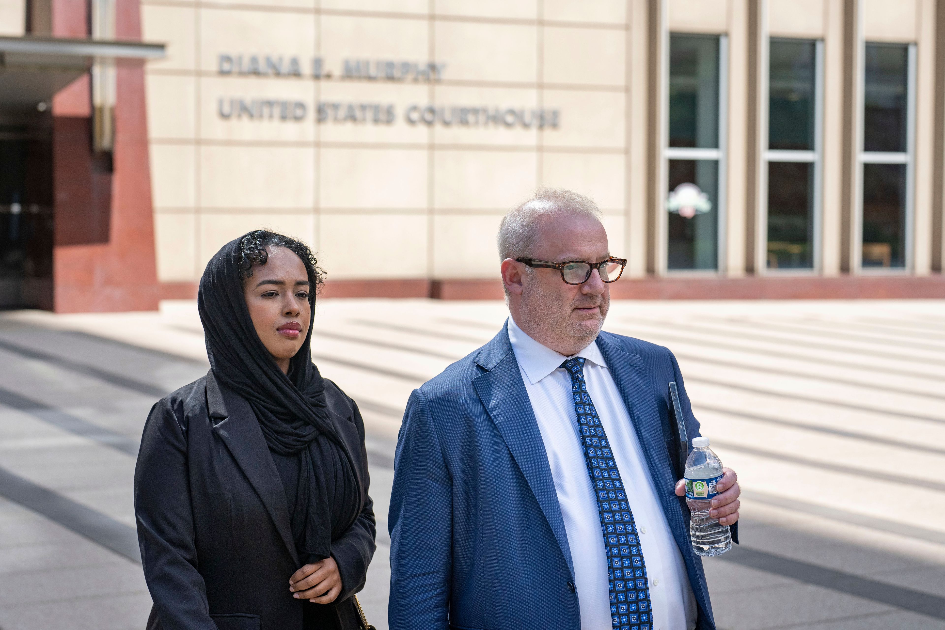 Ladan Mohamed Ali, left, a Seattle woman who attempted to bribe a Minnesota juror with a bag of $120,000 in cash in exchange for an acquittal in one of the country's largest COVID-19-related fraud cases, and her attorney, Eric Newmark, leave the Diana E. Murphy U.S. Courthouse, Thursday, Sept. 5, 2024, in Minneapolis, following after a hearing where she plead guilty.