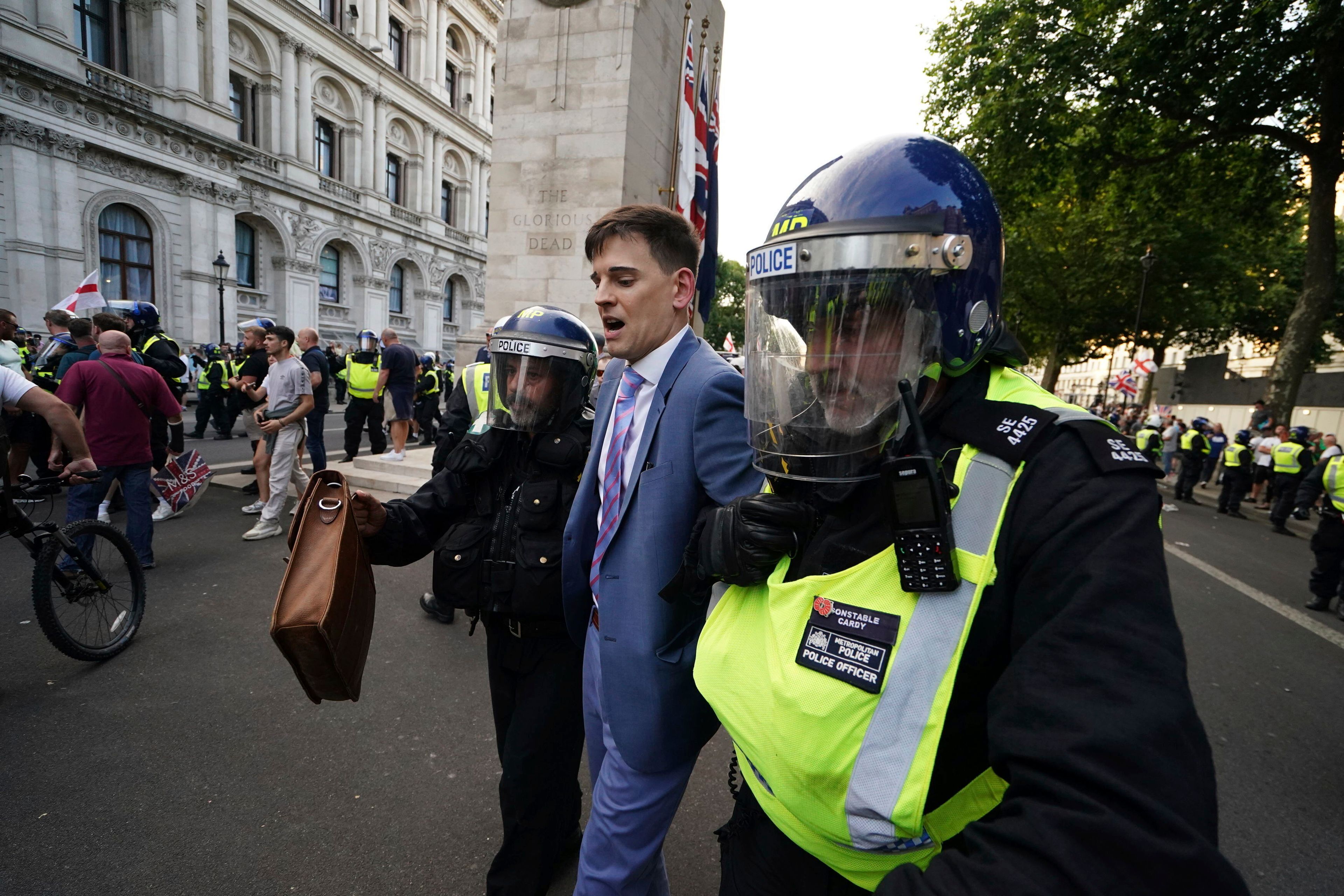 A man is detained as people attend the 'Enough is Enough' protest in Whitehall, London, Wednesday July 31, 2024, following the fatal stabbing of three children at a Taylor Swift-themed holiday club on Monday in Southport. (Jordan Pettitt/PA via AP)