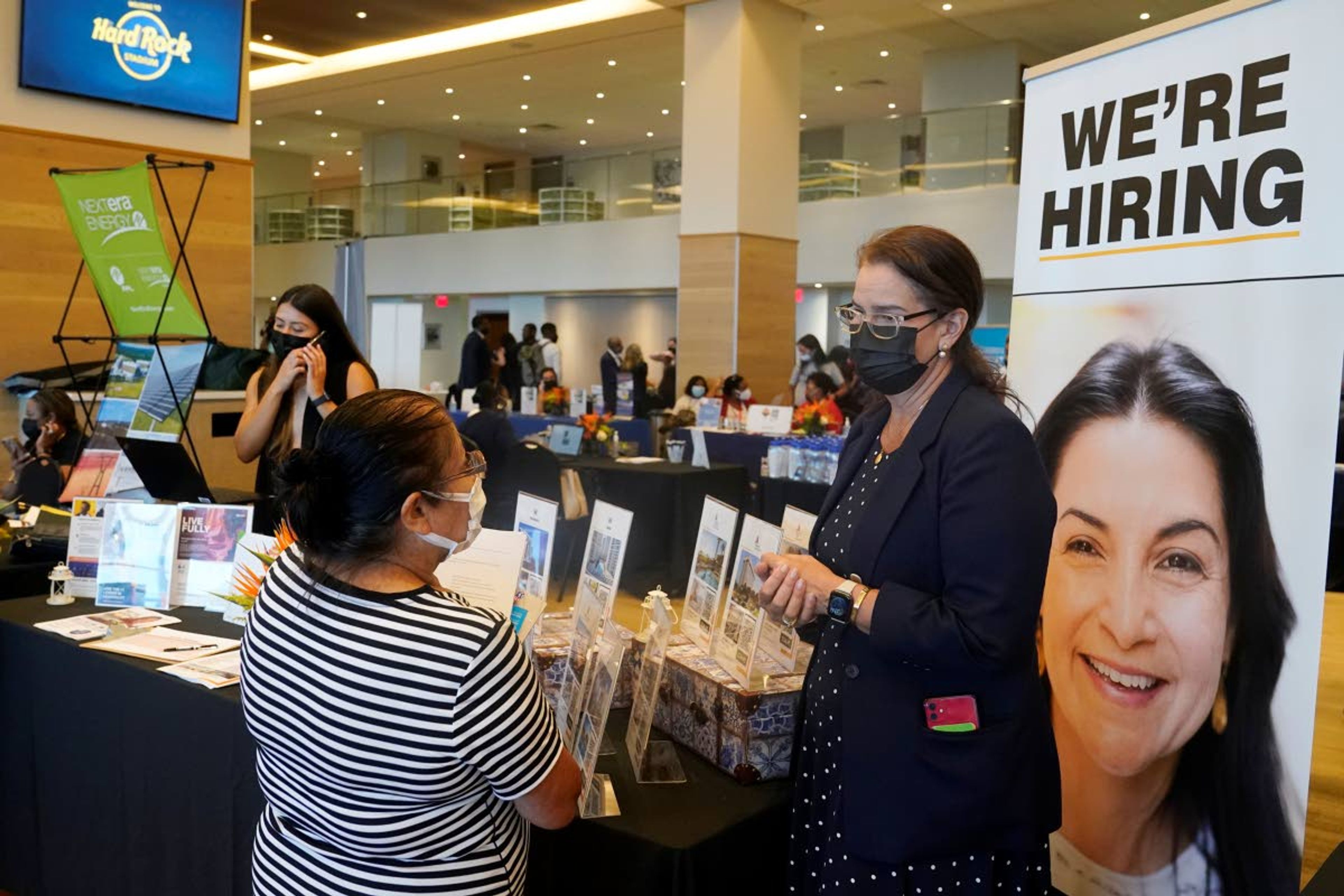 FILE - Marriott human resources recruiter Mariela Cuevas, left, talks to Lisbet Oliveros, during a job fair at Hard Rock Stadium, Friday, Sept. 3, 2021, in Miami Gardens, Fla. Americans quit their jobs at a record pace for the second straight month in September, while businesses and other employers continued to post a near-record number of available jobs. (AP Photo/Marta Lavandier, File)