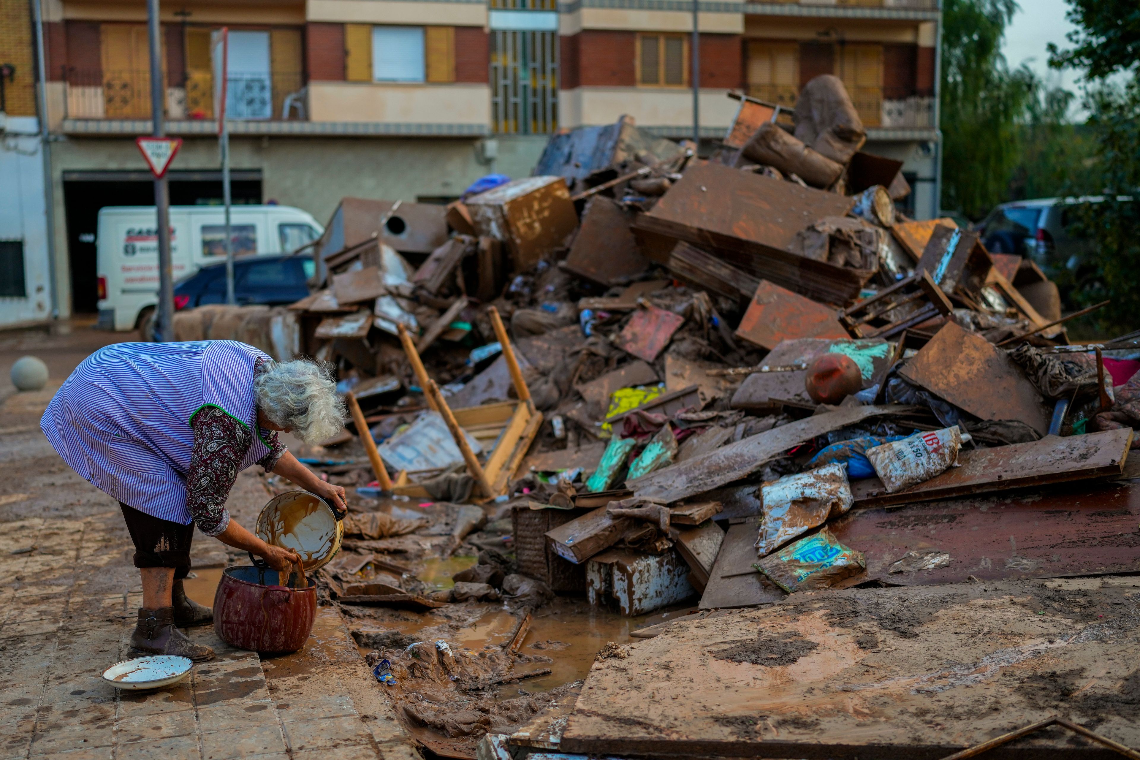 A woman cleans her house affected by floods in Utiel, Spain, Wednesday, Oct. 30, 2024. (AP Photo/Manu Fernandez)