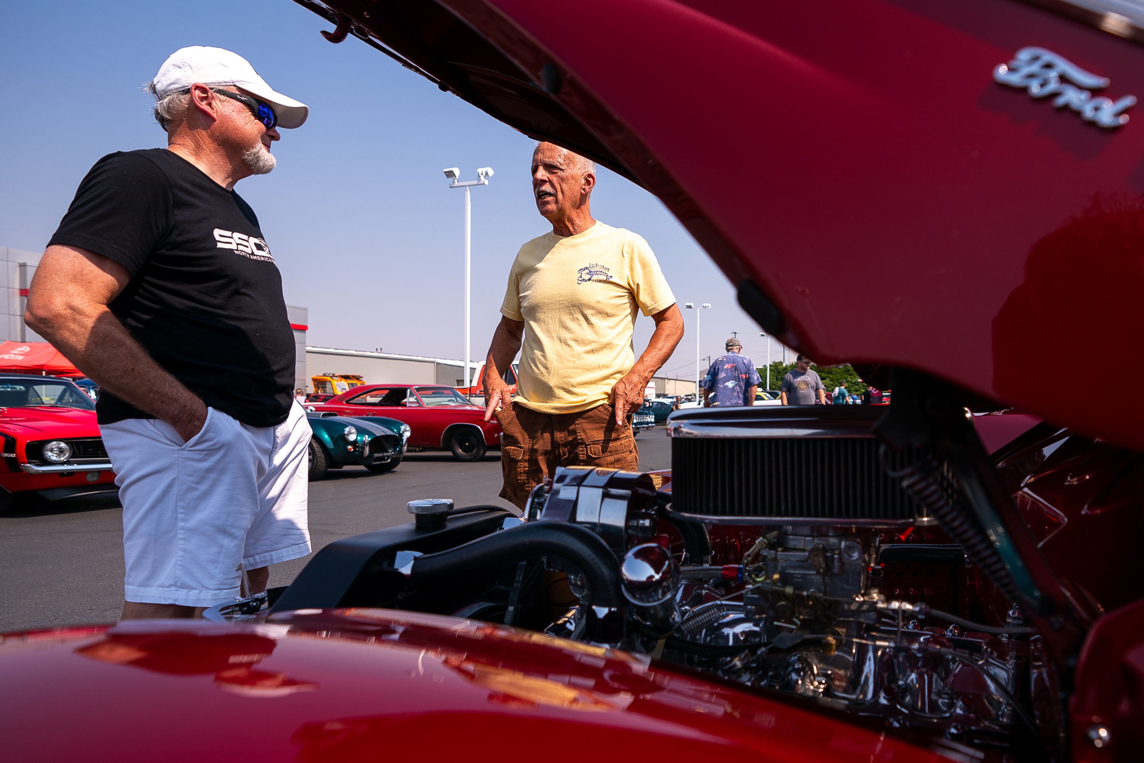 Jim McKelway, left, of Lewiston, talks to Paul Clark, of Battle Ground, WA, about his 1940 Ford Deluxe Convertible at the Rogers Toyota Show and Shine event on Thursday in Lewiston.