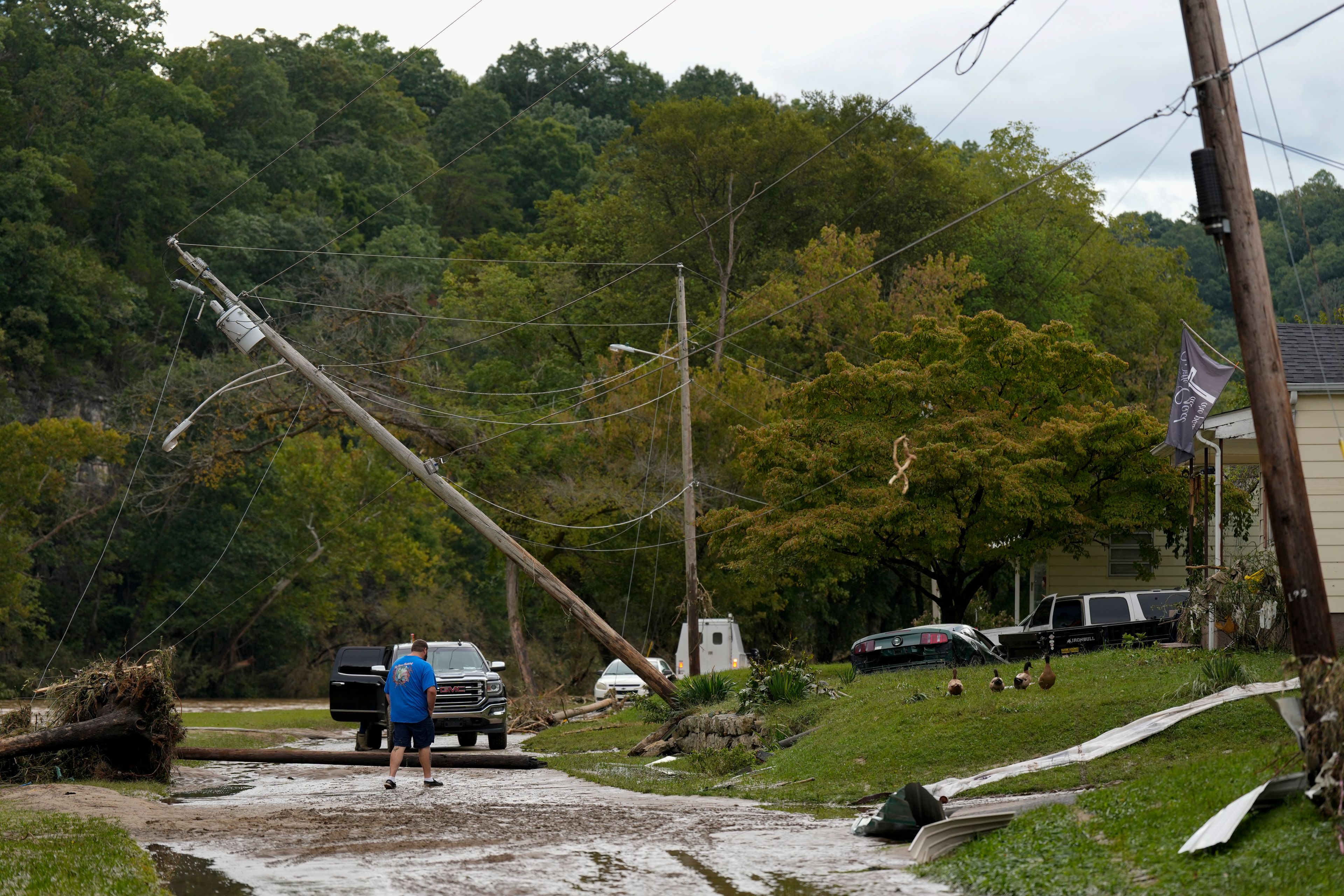 A person crosses River St. where flood damage is seen Saturday, Sept. 28, 2024, in Newport, Tenn. (AP Photo/George Walker IV)