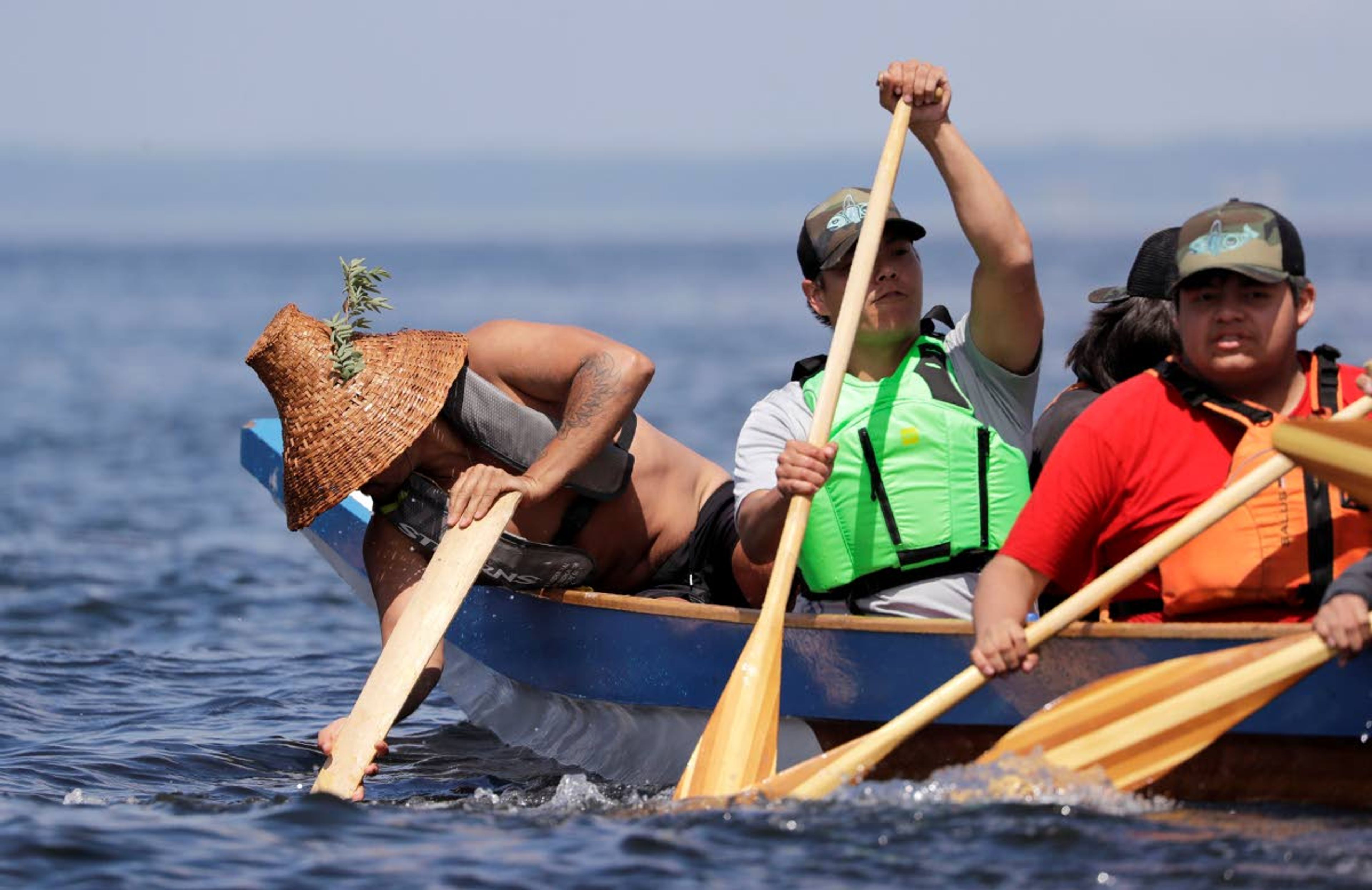 A tribal member leans over the side of his canoe to steer as others pull for shore during a stop on the annual tribal canoe journey through the Salish Sea Thursday in Seattle.