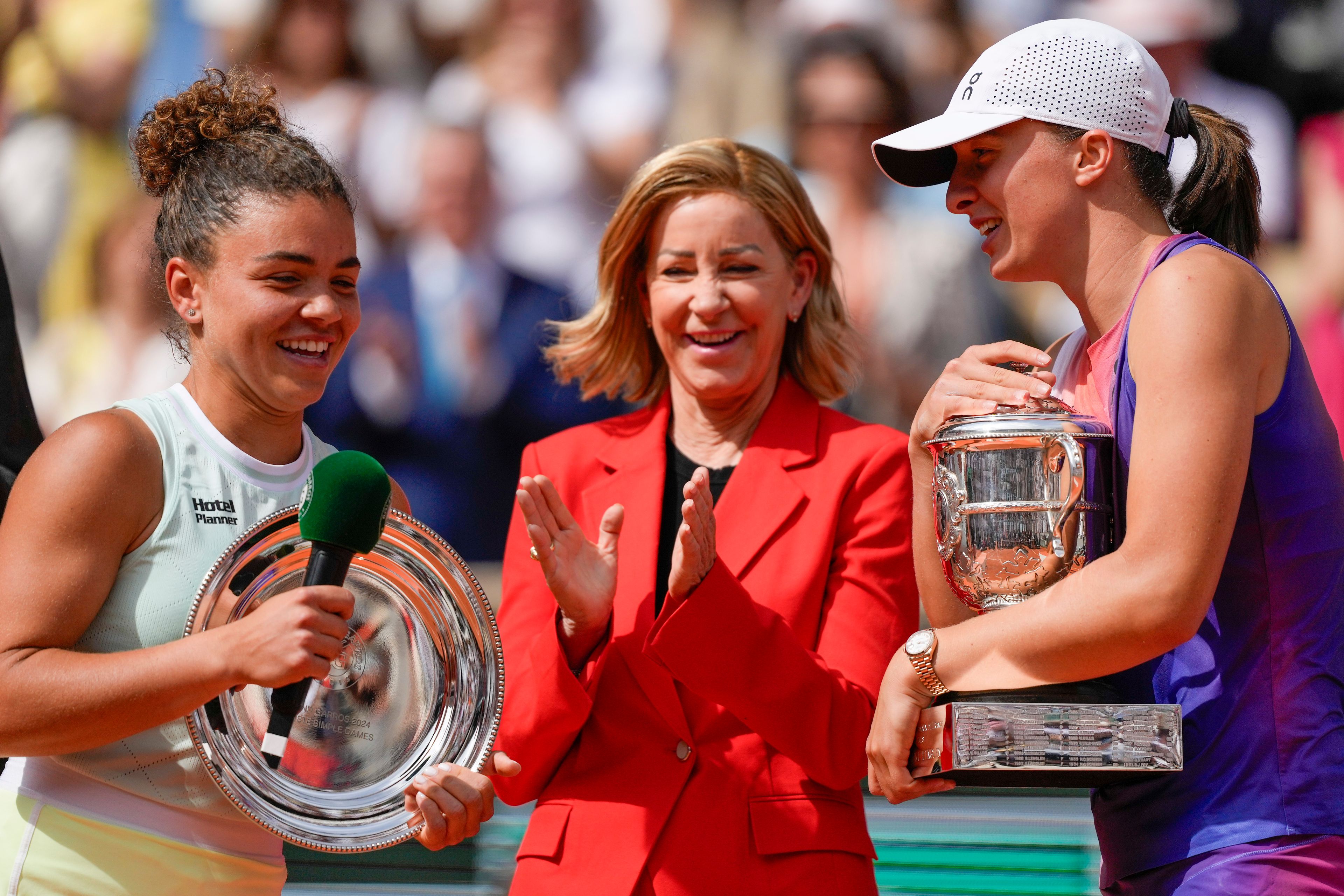 Poland's Iga Swiatek, right, holds the trophy after winning the women's final of the French Open tennis tournament against Italy's Jasmine Paolini, left, at the Roland Garros stadium in Paris, France, Saturday, June 8, 2024.