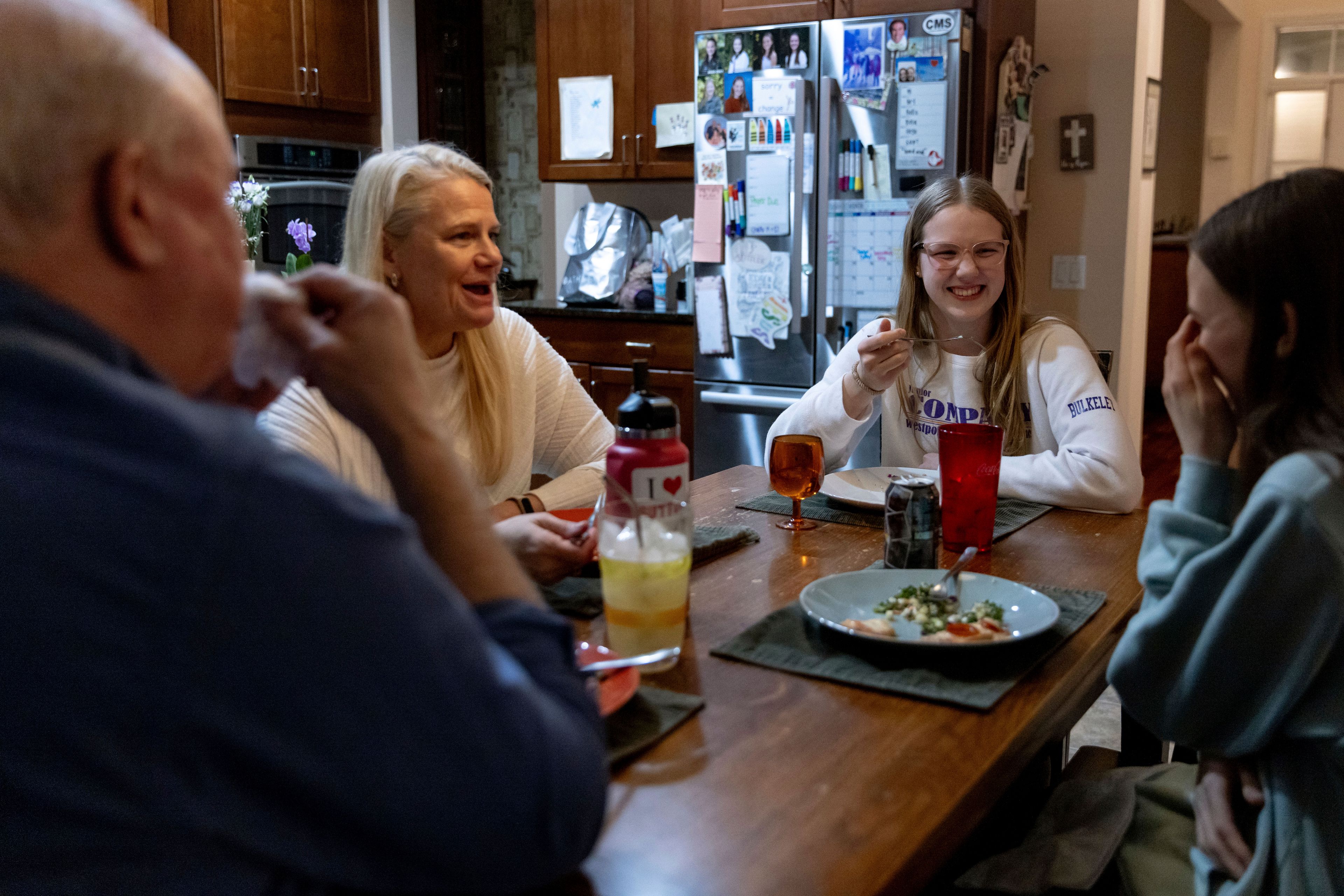 Kate Bulkeley, second from right, eats dinner with her family, Friday, Feb. 16, 2024, in Westport, Conn. With the damaging consequences of social media increasingly well documented, many parents are trying to raise their children with restrictions or blanket bans. Teenagers themselves are aware that too much social media is bad for them, and some are initiating social media “cleanses” because of the toll it takes on mental health and grades.