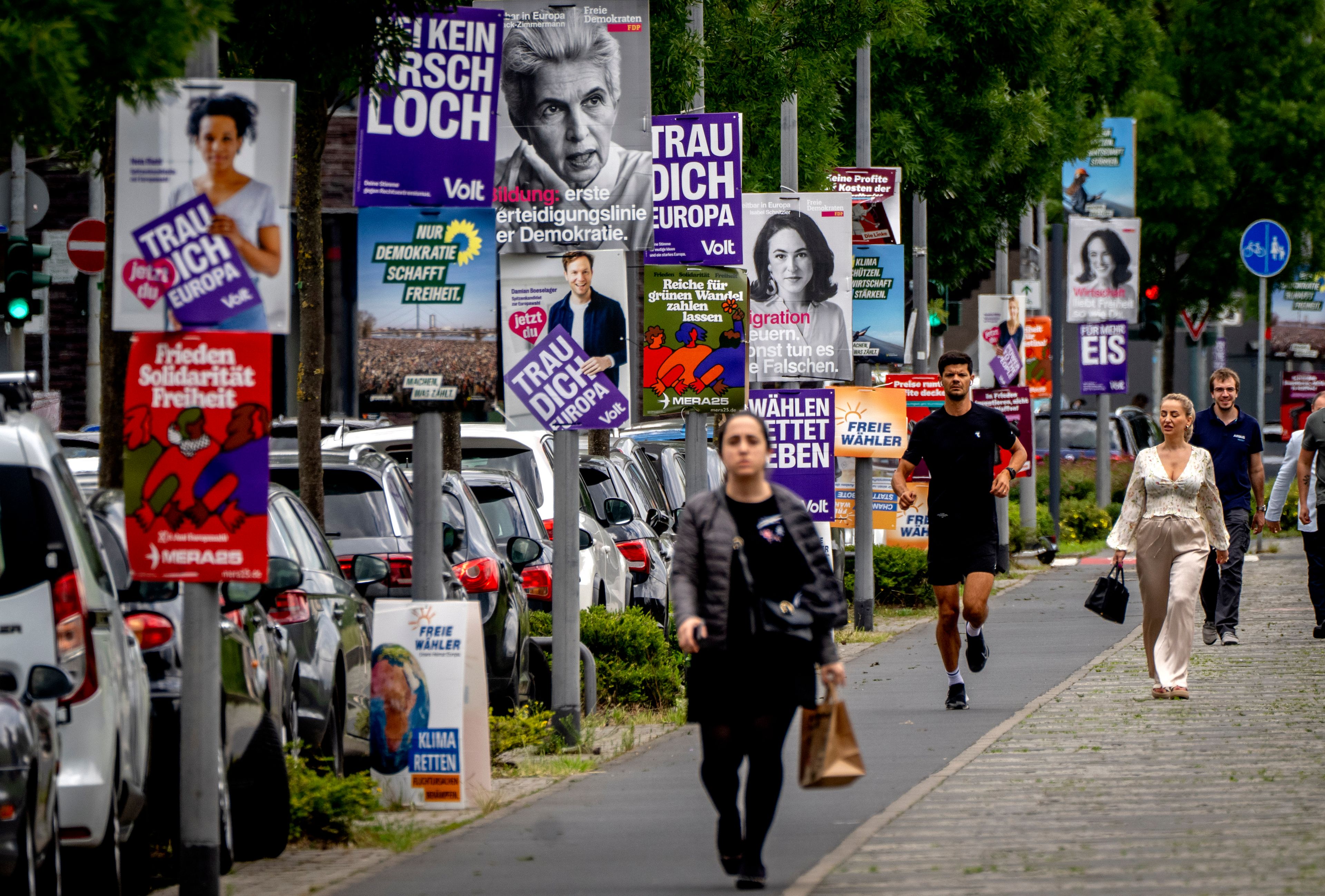 People walk past elections posters for the European elections in Frankfurt, Germany, Thursday, June 6, 2024.