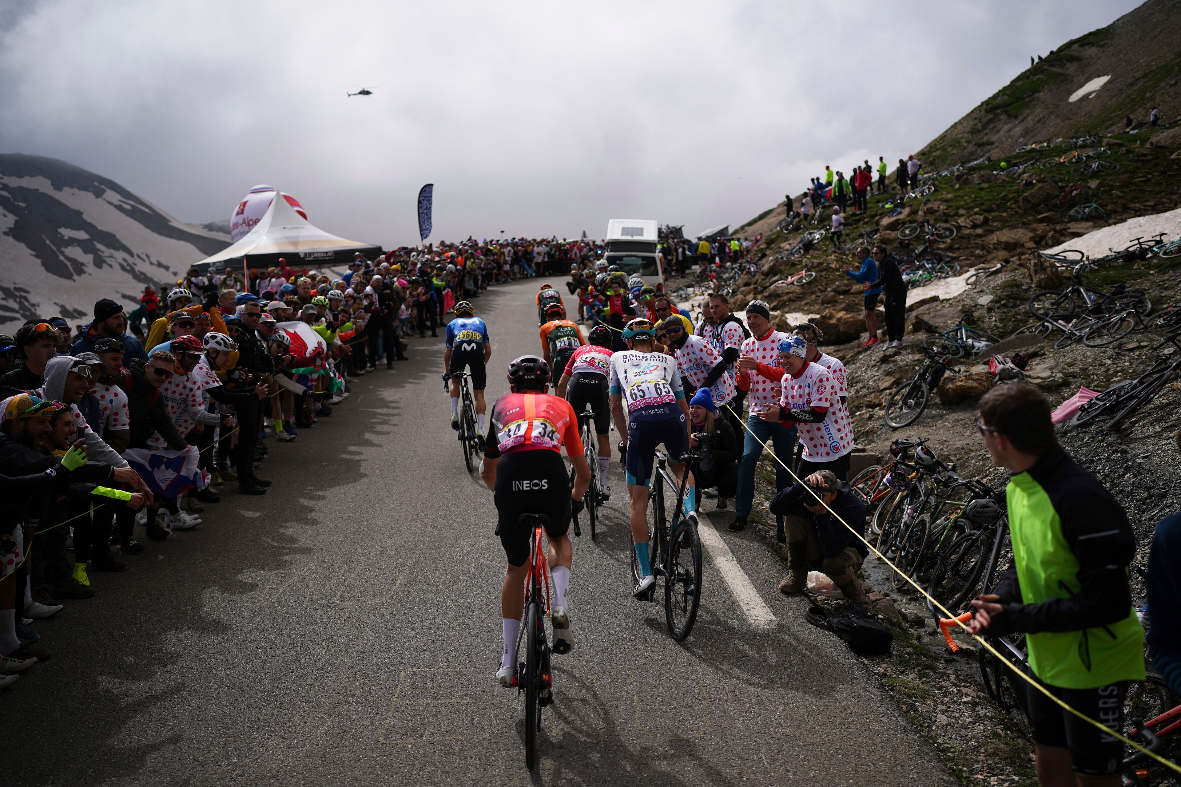 Belgium's Laurens de Plus, center, rides to climb the Col du Galibier during the fourth stage of the Tour de France cycling race over 139.6 kilometers (86.7 miles) with start in Pinerolo, Italy and finish in Valloire, France, Tuesday, July 2, 2024. (AP Photo/Daniel Cole)