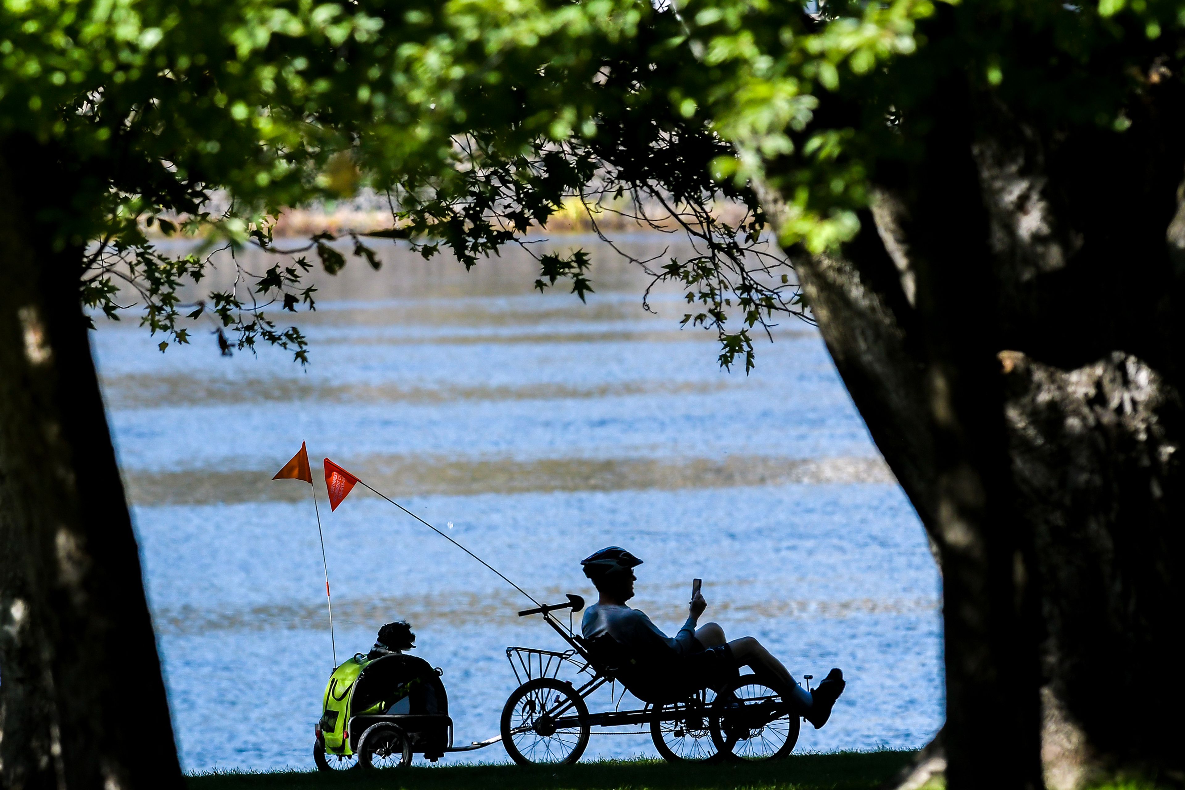 A bicyclist with dog in tow rides down the pathway at Hells Gate State Park Friday in Lewiston.,