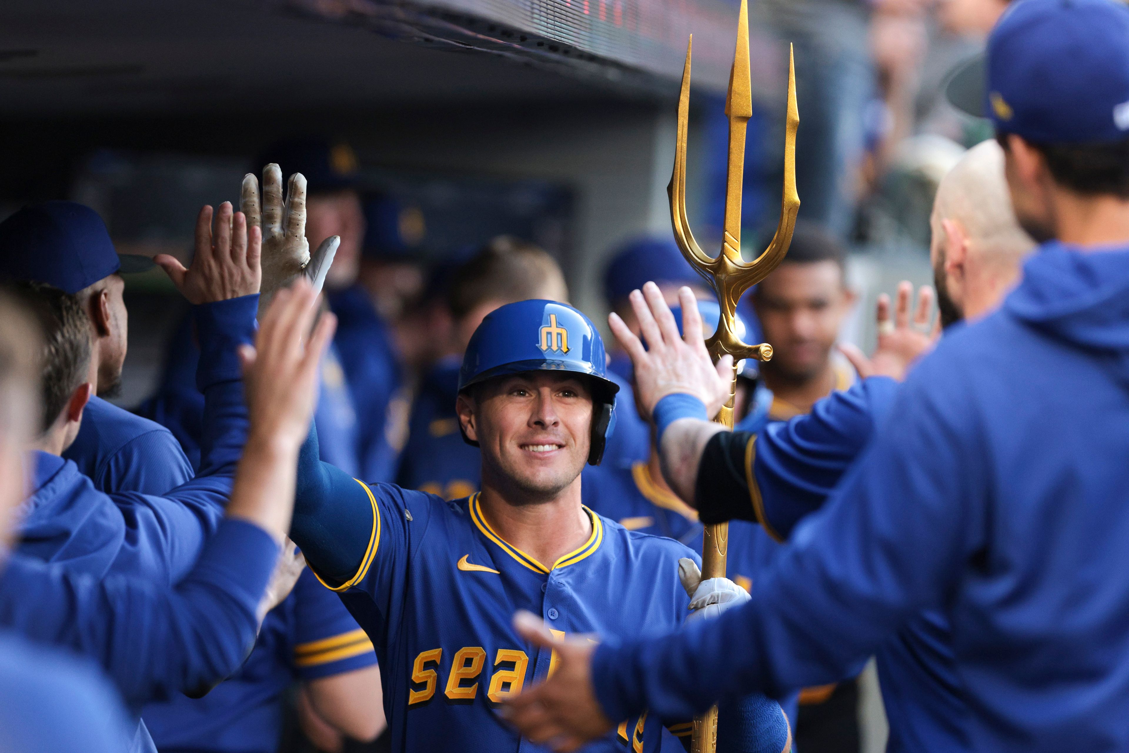 The Mariners' Dylan Moore celebrates in the dugout after his two-run home run during a game against the Athletics on Friday in Seattle.