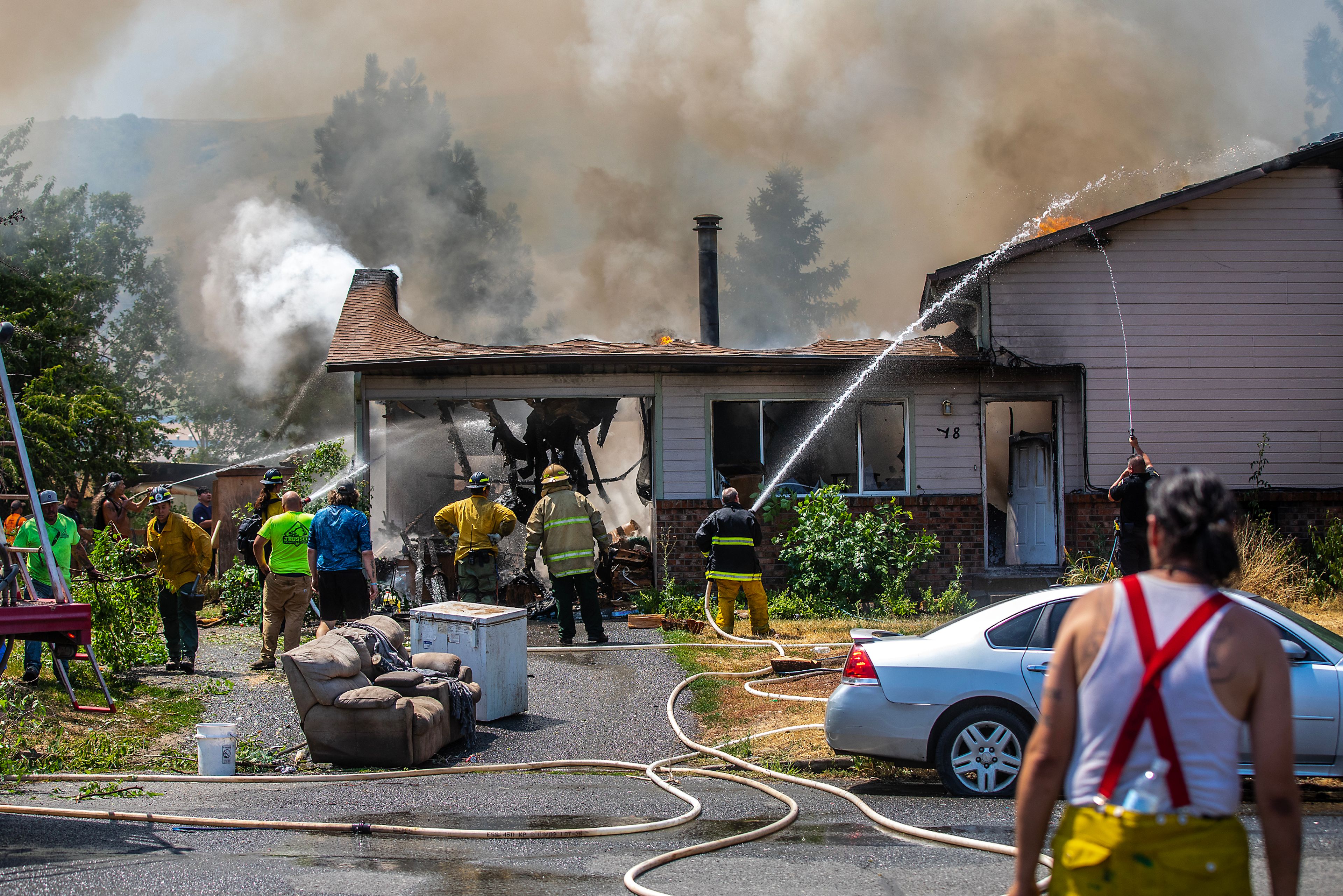 Firefighters from various agencies spray down a structure fire Friday on Lolo Street in Lapwai.