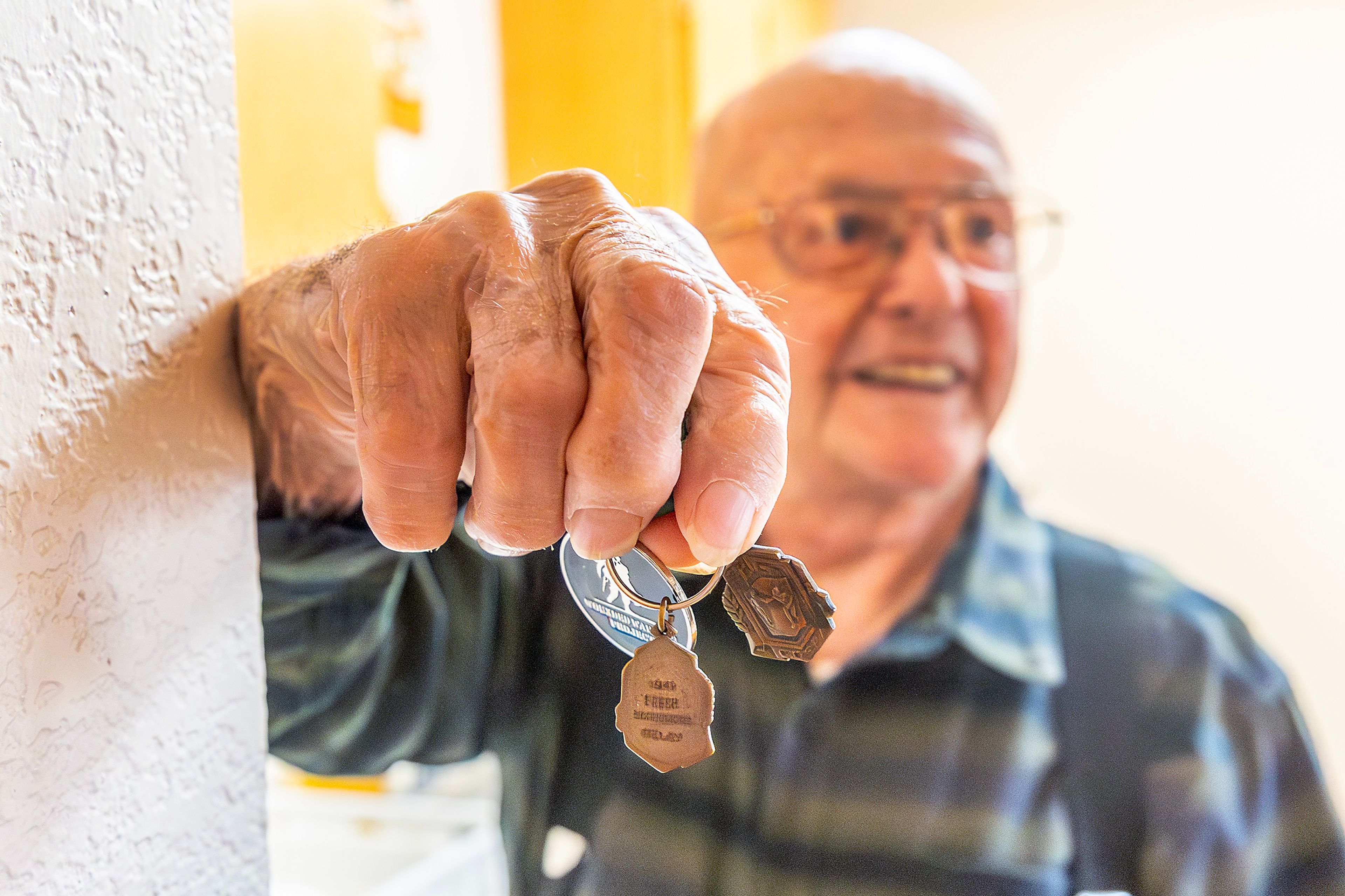 Johnny Wells holds out a Wounded Warrior Project medallion and other medals he received from competing in track Tuesday in Clarkston.