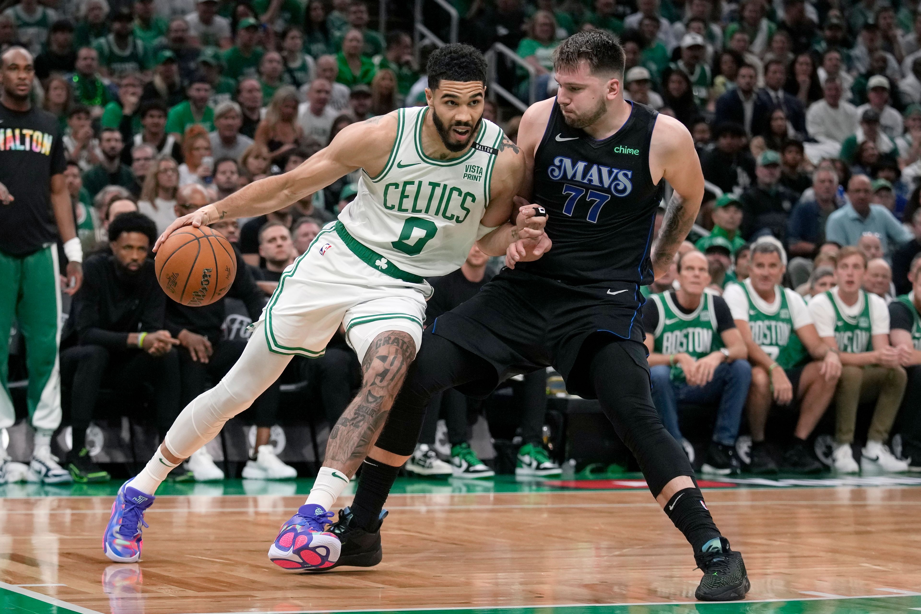 Boston Celtics forward Jayson Tatum (0) drives toward the basket as Dallas Mavericks guard Luka Doncic (77) defends during the first half of Game 1 of basketball's NBA Finals on Thursday, June 6, 2024, in Boston.