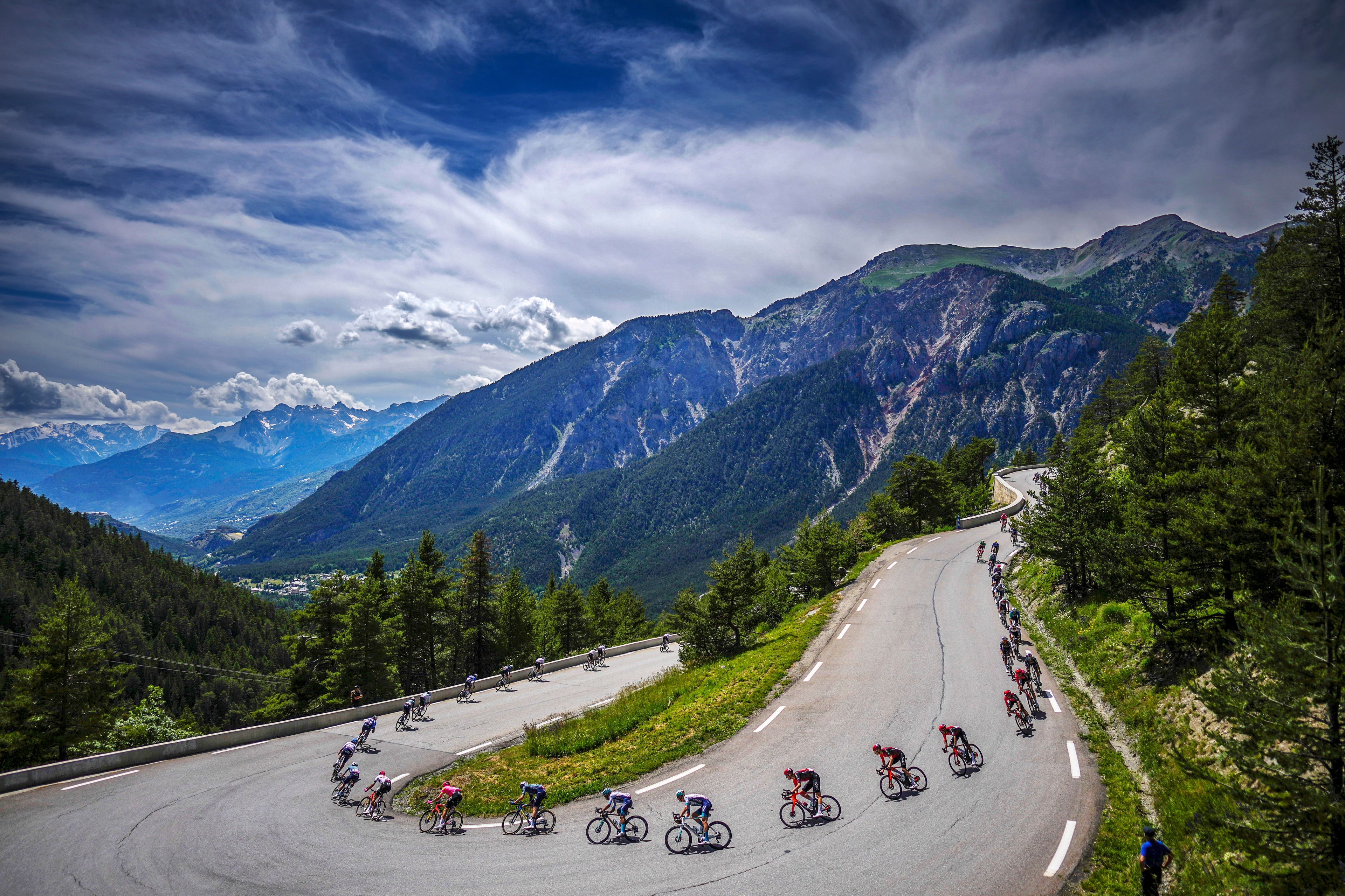 The peloton rides downhill during the fourth stage of the Tour de France over 139.6 kilometers with start in Pinerolo, Italy and finish in Valloire, France, Tuesday, July 2, 2024. (AP Photo/Daniel Cole)