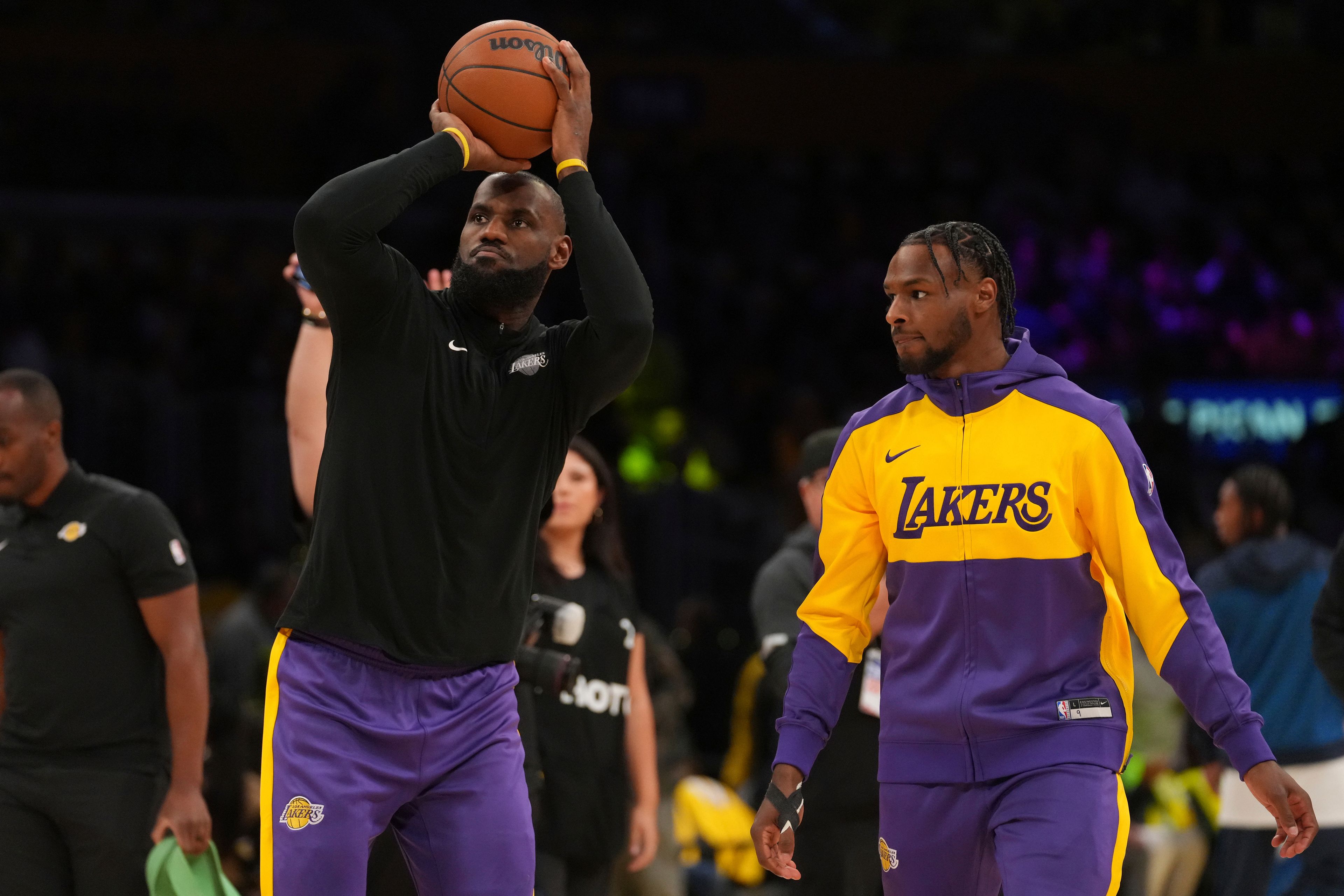 Los Angeles Lakers forward LeBron James, left, and guard Bronny James warm up before an NBA basketball game against the Minnesota Timberwolves, Tuesday, Oct. 22, 2024, in Los Angeles. (AP Photo/Eric Thayer)