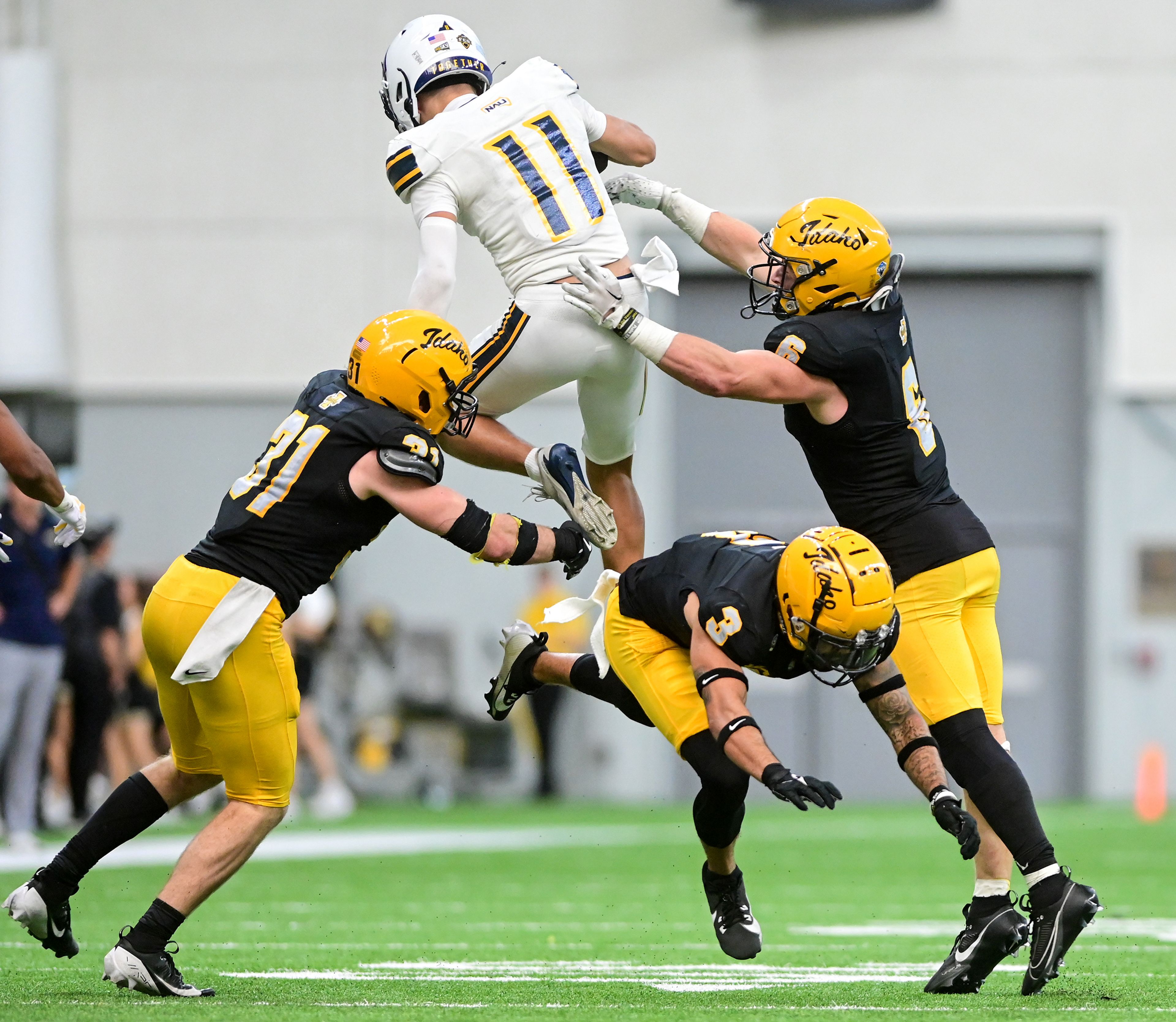 Northern Arizona wide receiver Kolbe Katsis leaps over Idaho defensive back K.J. Trujillo on Saturday, Oct. 5, 2024, at the P1FCU Kibbie Dome in Moscow. Katsis was tackled by Idaho linebacker Jaxton Eck, right.,