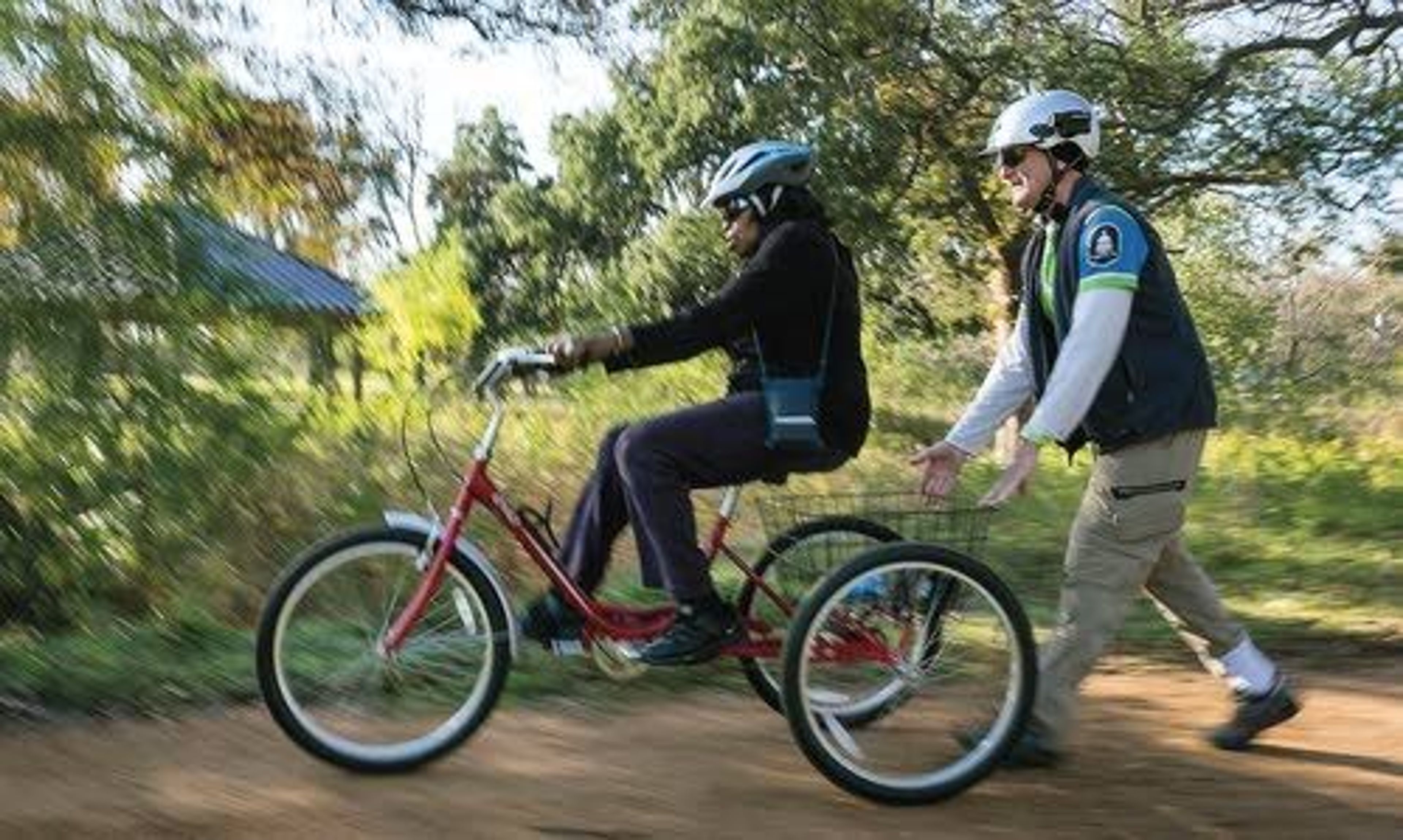 Bike Austin instructor Preston Tyree (right) helps push and offers instructions to Bertha Sellers, 75, as she pedals her trike bike on a ride with the Ghisallo Cycling Initiative.