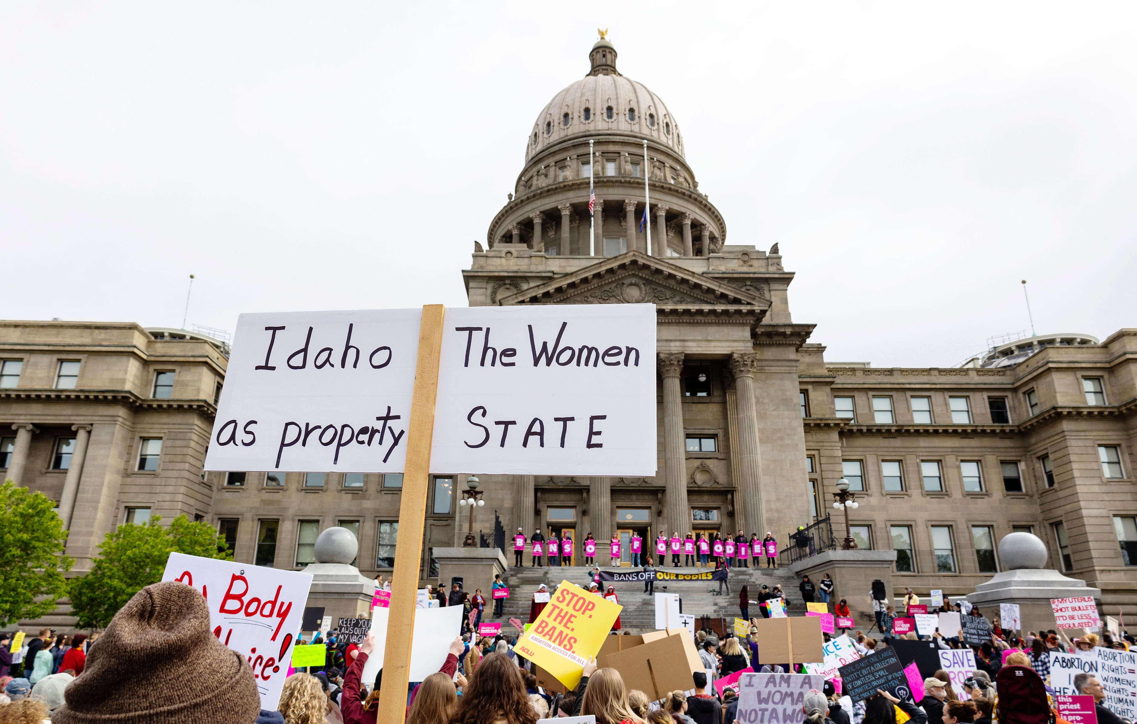 FILE - An attendee at Planned Parenthood's Bans Off Our Bodies rally for abortion rights holds a sign reading "Idaho the women as property state" outside of the Idaho Statehouse in downtown Boise, Idaho, on May 14, 2022. A University of Idaho memo warning staffers not to refer students to abortion or birth control providers has placed the school at the center of a debate over First Amendment rights and access to reproductive health care. One of the laws bars the use of state funds to promote or endorse abortion or emergency contraception. Another makes it illegal for non-healthcare providers to advertise abortions or birth control. (Sarah A. Miller/Idaho Statesman via AP, File)