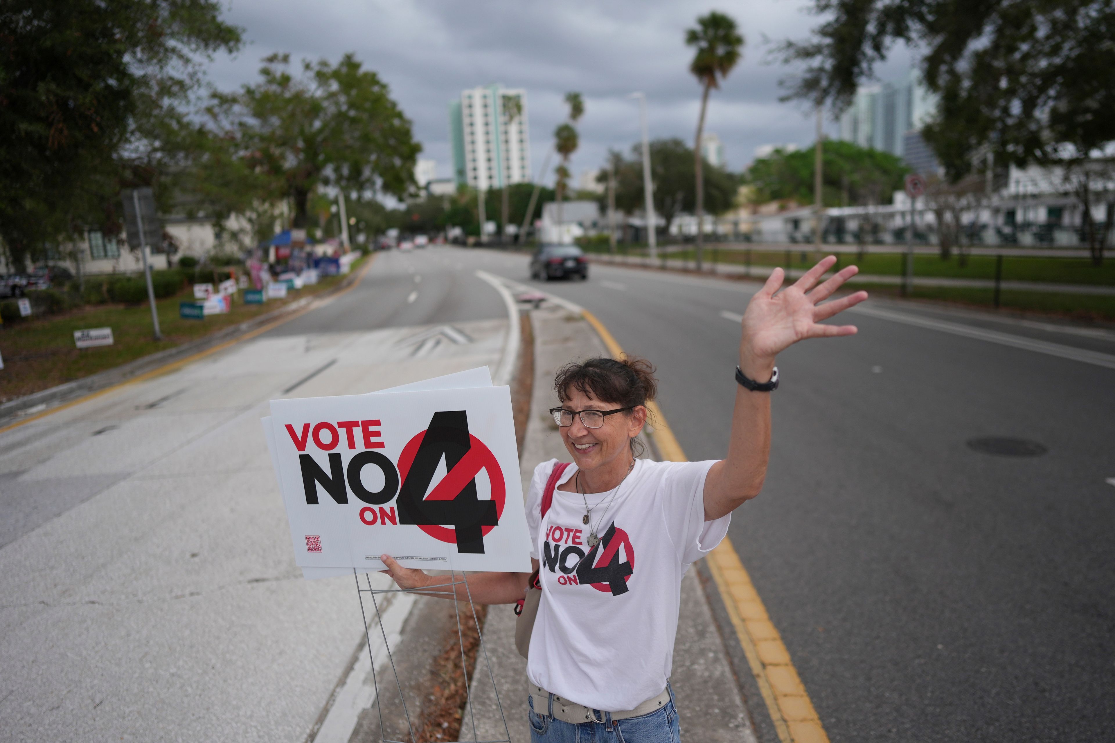 CORRECTS LANGUAGES TO MATCH AP STYLE - Anti-abortion Catholic Sonja Kahkonen waves to passing cars as she holds a "Vote No on 4" sign, urging voters to reject Amendment 4, which would enshrine abortion rights in the state, on Election Day, Tuesday, Nov. 5, 2024, outside a polling place at the Coliseum in St. Petersburg, Fla. (AP Photo/Rebecca Blackwell)