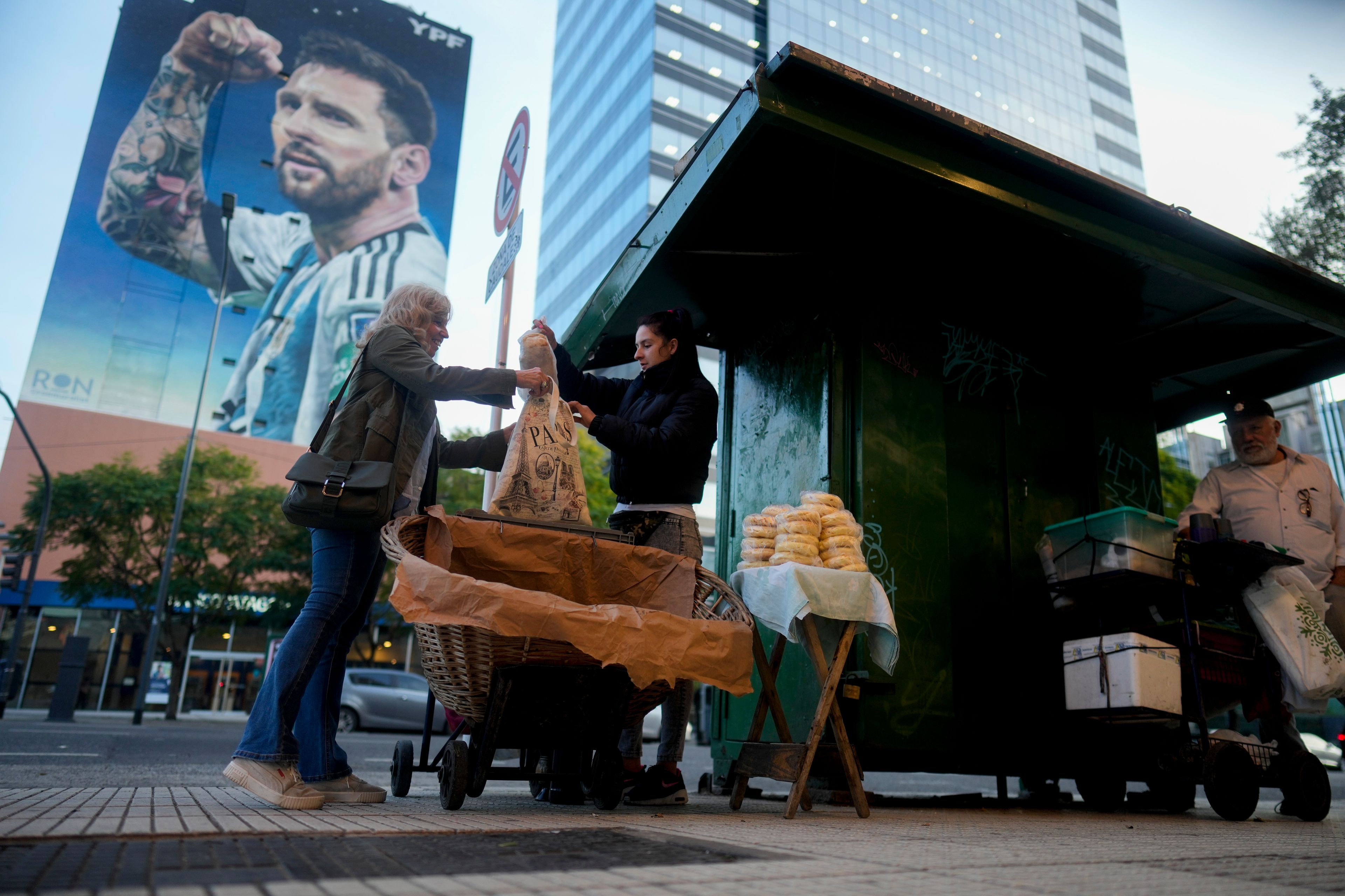 Veronica Vera, center, sells bread on the sidewalk in Buenos Aires, Argentina, Friday, Sept. 20, 2024. (AP Photo/Natacha Pisarenko)