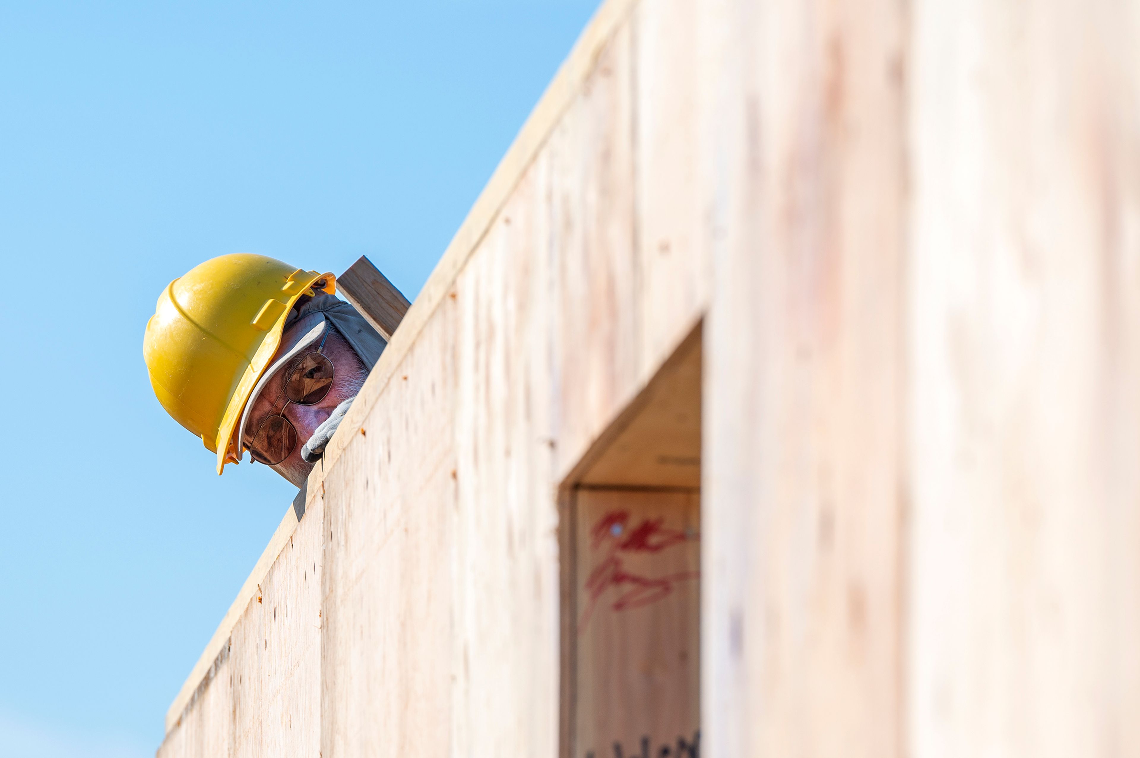 Volunteer Dan Hardesty peeks over the wall of a home being constructed by volunteers of Palouse Habitat for Humanity on Leepike Court in Moscow.