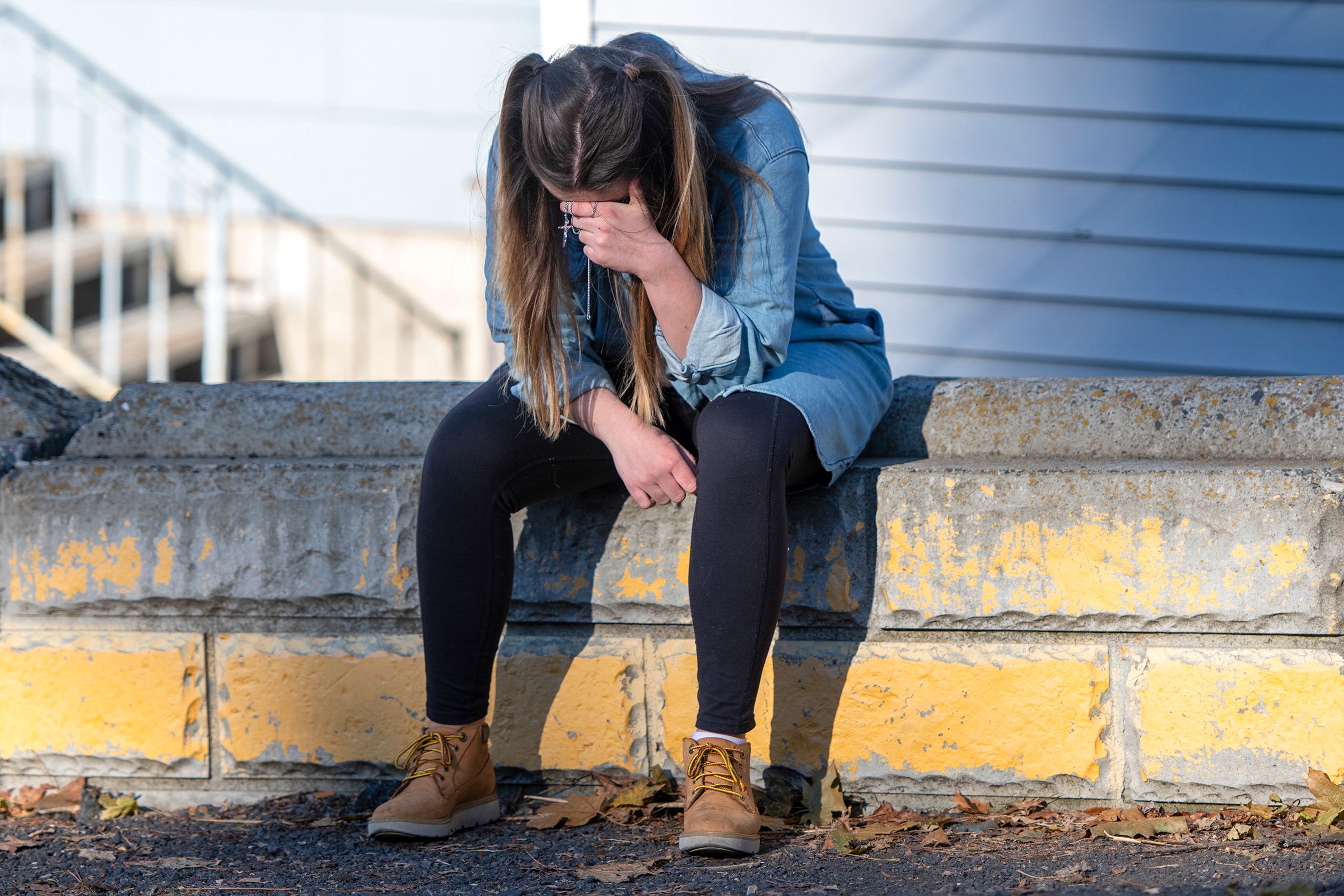 University of Idaho student Alaina Tempelis, of Seattle, prays with a cross in-hand outside of the home where four fellow students were murdered in Moscow on Thursday. Tempelis said she frequently ate at Mad Greek in downtown where Xana Kernodle and Madison Mogen worked for several years.