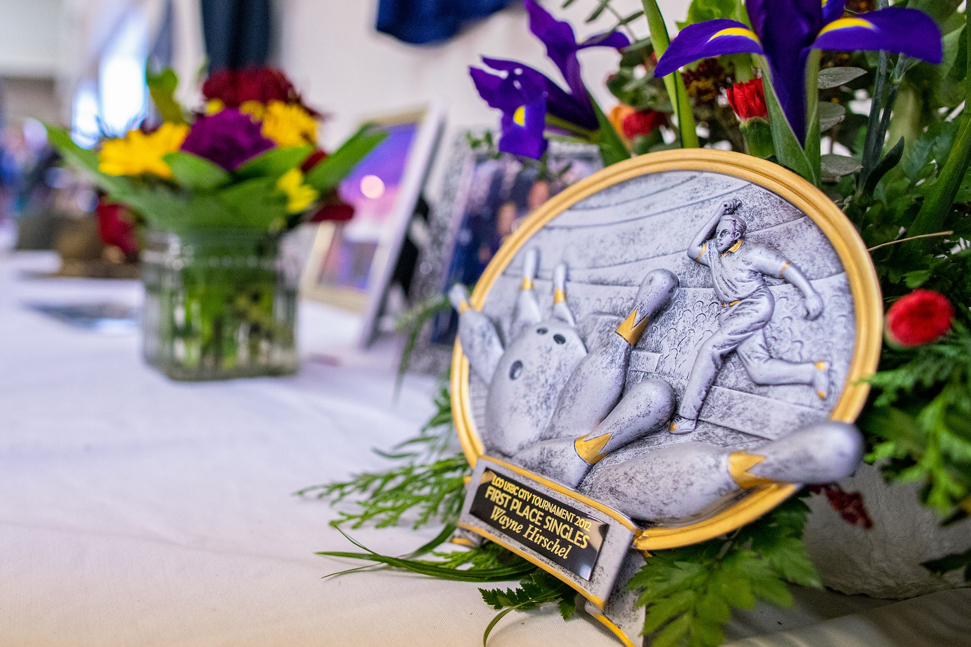 One of Wayne Hirschel’s many bowling accolades sits with a wreath of flowers Saturday at his memorial in the Bennett Building of the Asotin County Fairgrounds in Asotin. Hirschel bowled six perfect 300 games in his career and was inducted into the LCO Bowling Hall of Fame as recognition of attending the National Bowling Tournament for 40 years.