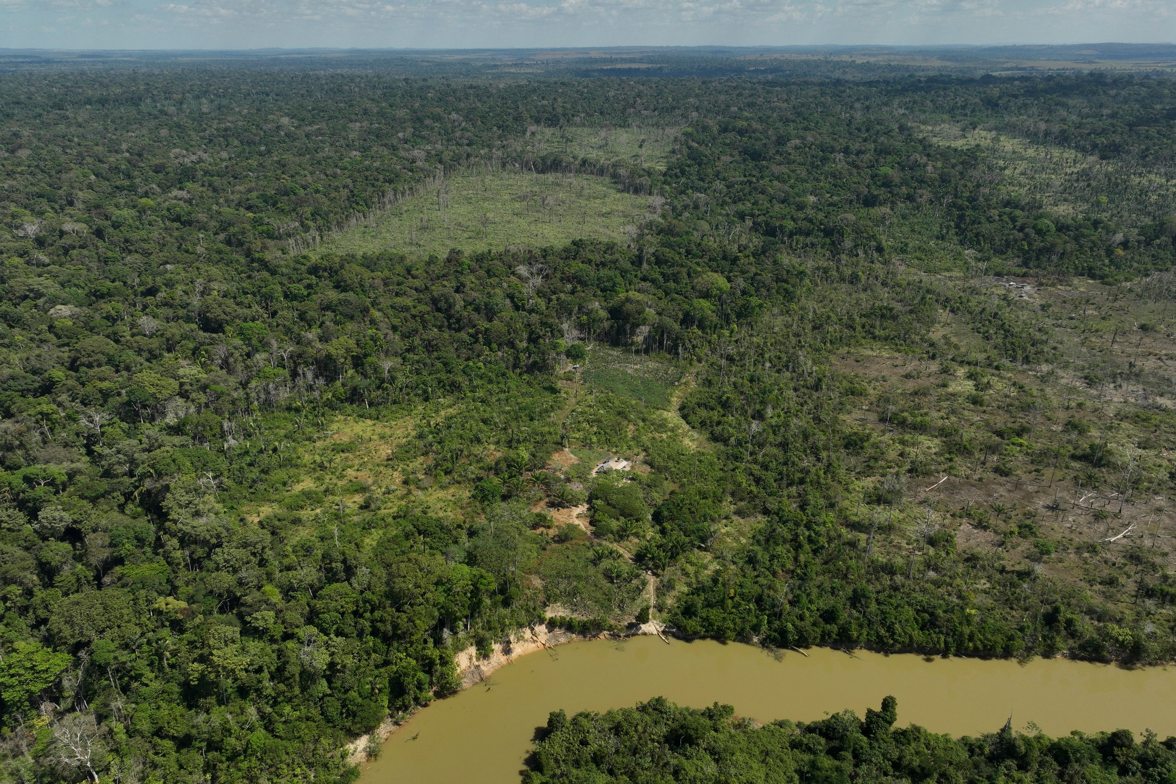 FILE - A river borders an area that has been illegally deforested by land-grabbers and cattle farmers in an extractive reserve in Jaci-Parana, Rondonia state, Brazil, July 11, 2023.