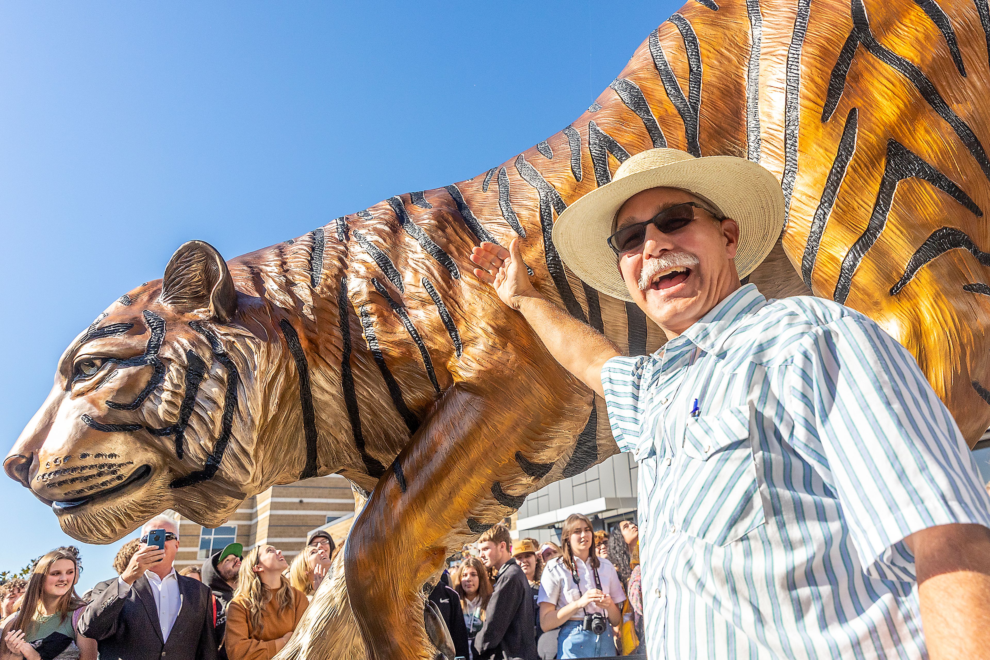 Artist Shayne Watkins stands next to the bengal statue as it is unveiled Thursday at Lewiston High School.