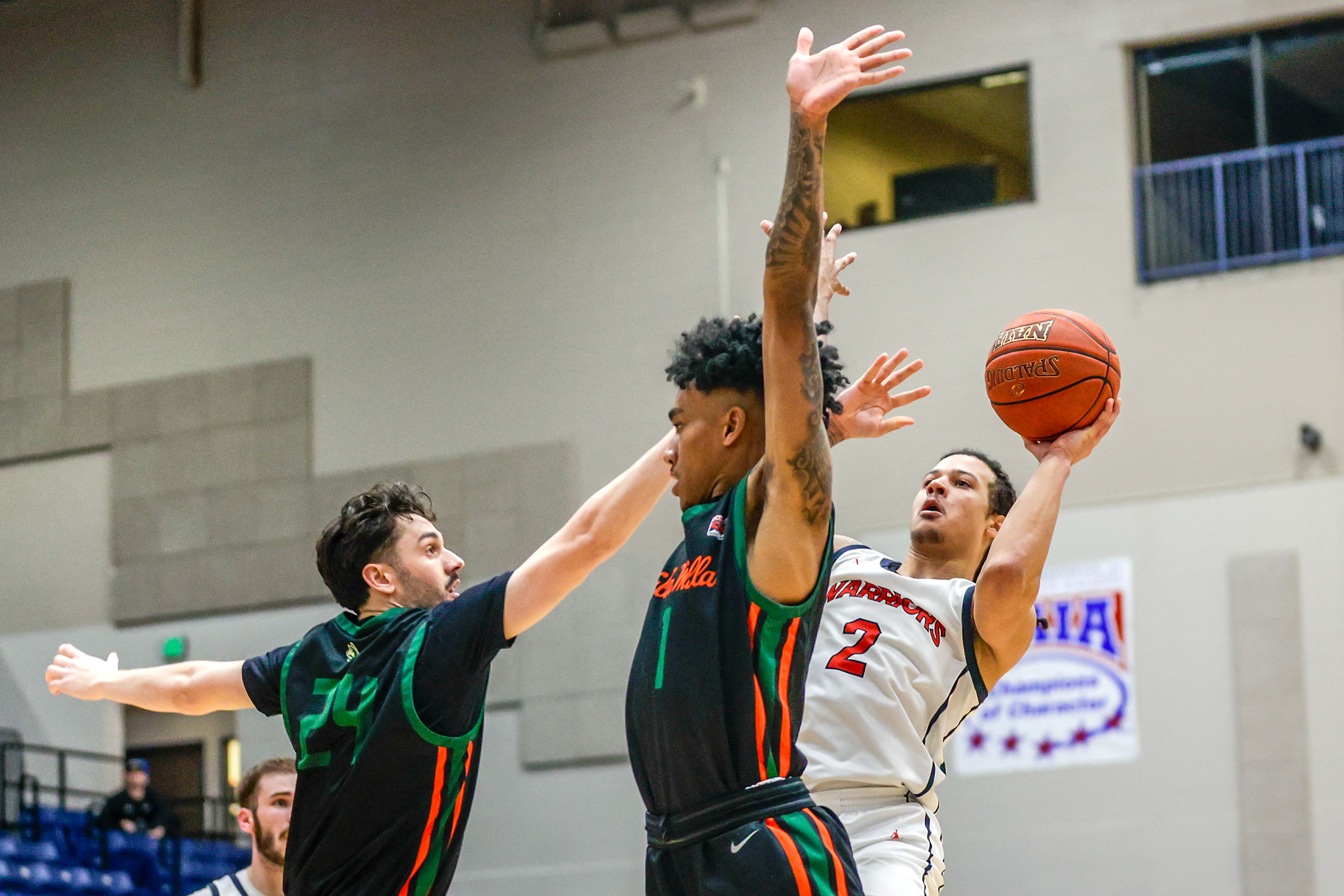 Lewis-Clark State guard MaCarhy Morris leans back to shoot the ball as Walla Walla Forward Steele Twiford (24) and guard Chike Ezeonu guards him during a quarter of a Cascade Conference game Tuesday at Lewis-Clark State College in Lewiston.