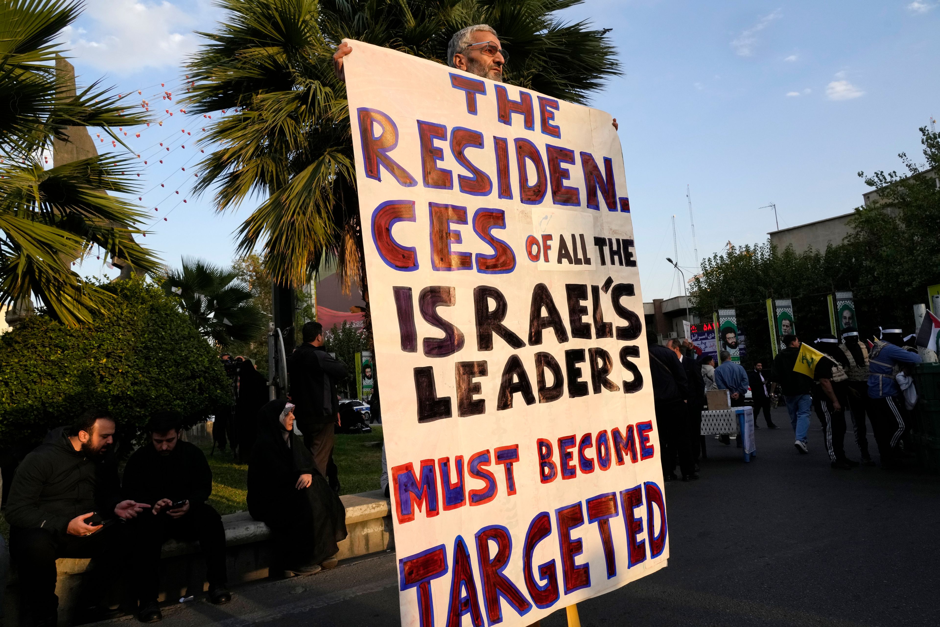 An Iranian demonstrator holds an anti-Israeli banner in a ceremony commemorating the late Hamas leader Yahya Sinwar and Hashem Safieddine, a powerful cleric who was expected to succeed slain Hezbollah leader Hassan Nasrallah and was killed by an Israeli airstrike in Beirut, at the Felestin (Palestine) Sq. in Tehran, Iran, Thursday, Oct. 24, 2024. (AP Photo/Vahid Salemi)