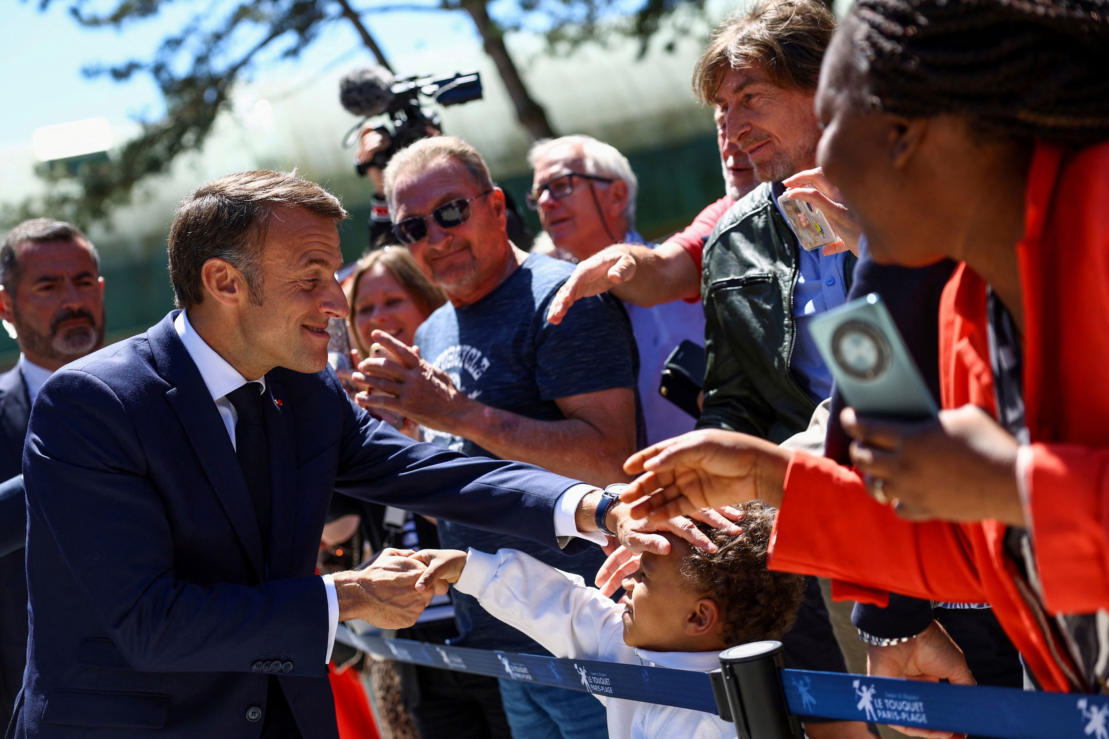 French President Emmanuel Macron greets a child after voting for the European election, Sunday, June 9, 2024 in Le Touquet-Paris-Plage, northern France. Polling stations opened across Europe on Sunday as voters from 20 countries cast ballots in elections that are expected to shift the European Union's parliament to the right and could reshape the future direction of the world's biggest trading bloc.