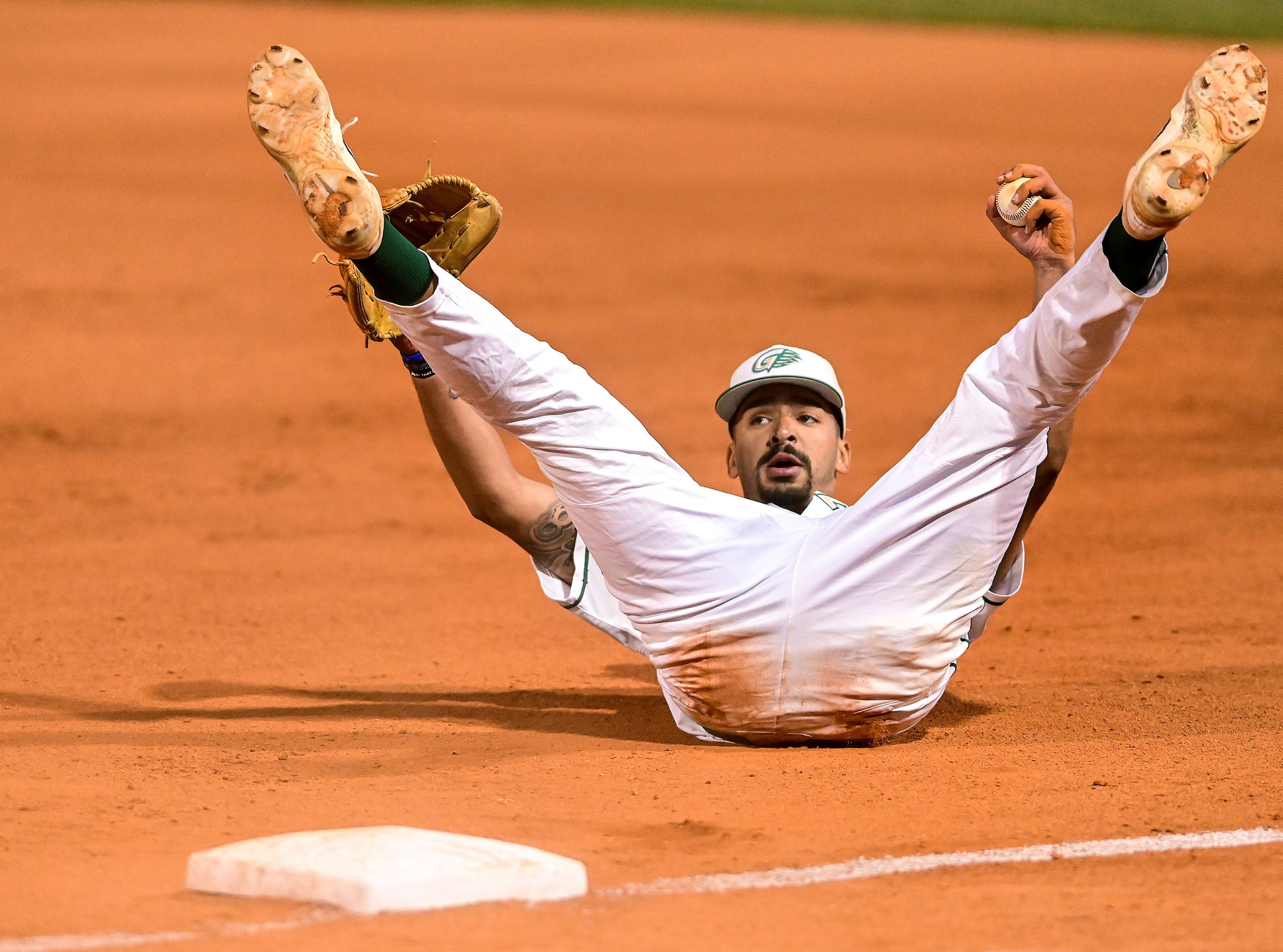 Georgia Gwinnett pitcher Kaleb Hill rolls backwards on the ground after printing to first base to tag out Indiana Southeast’s Colin Long at the NAIA World Series at Harris Field in Lewiston on Friday.