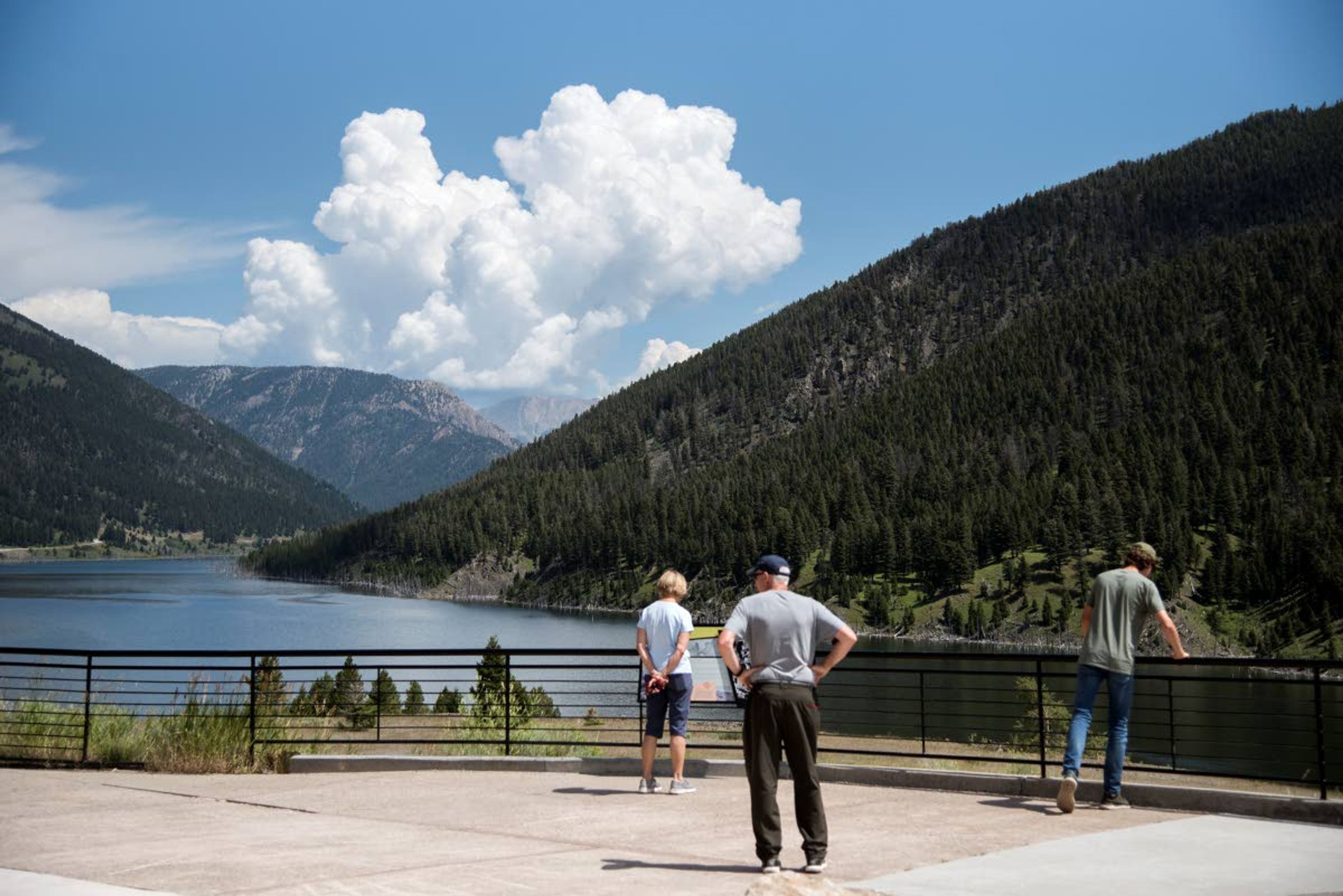 Patrons of the Earthquake Lake Visitor Center gaze out over the lake on Aug. 1, 2019. An earthquake had disrupted the full-moon night of Aug. 17, 1959, turning it chaotic and terrifying. The quake had a magnitude of 7.3, and it remains the largest to hit the region. The landslide also stopped the river. The water backed up and spread out, turning a swath of canyon into an ominous lake. (Rachel Leathe/Bozeman Daily Chronicle via AP)