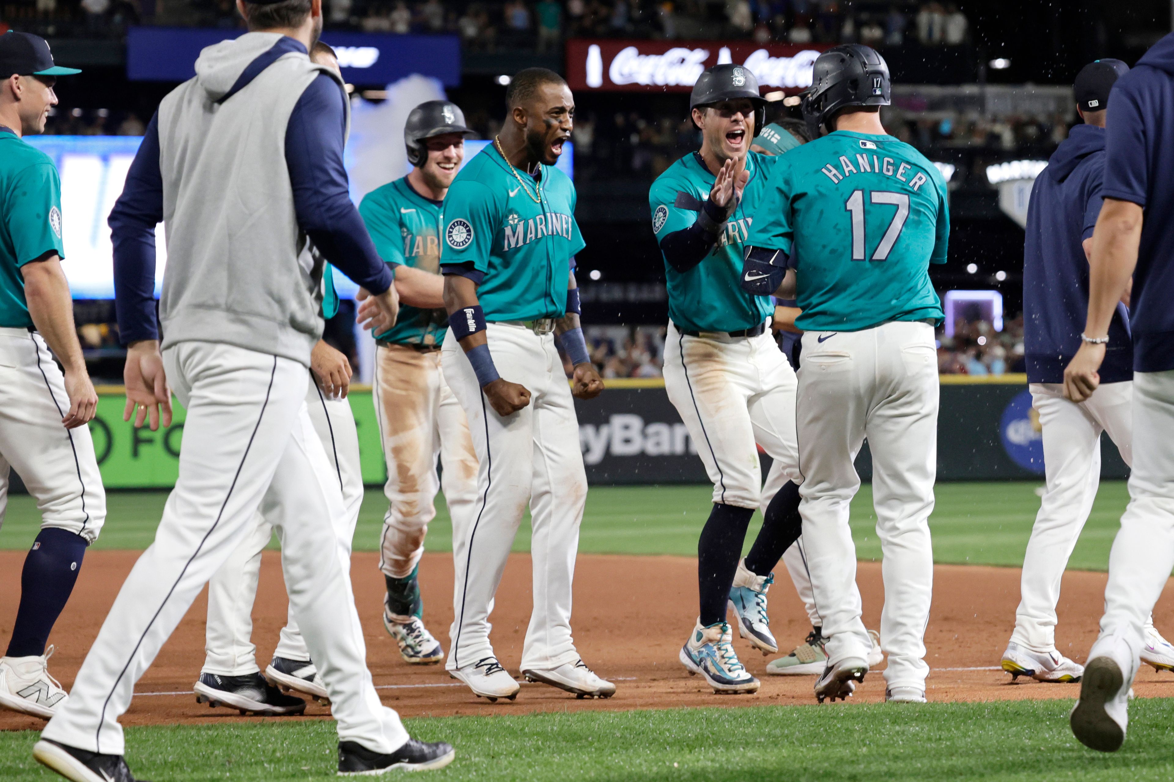 Seattle Mariners players celebrate a walk-off walk drawn by Mitch Haniger (17) to win 6-5 against the Philadelphia Phillies during the 10th inning in a baseball game Saturday, Aug. 3, 2024, in Seattle. (AP Photo/John Froschauer)