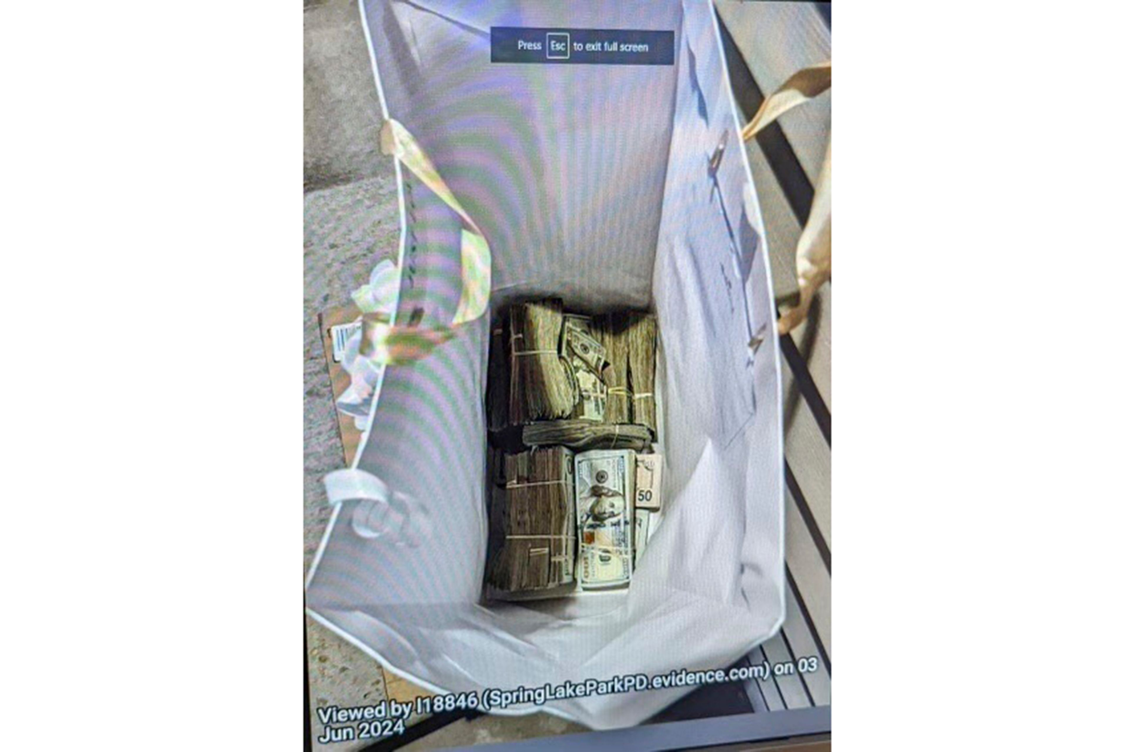 This photo supplied by the U.S. Attorney's Office for Minnesota shows cash from a bag that was left at the home of a juror in a massive fraud case, June 2, 2024, outside Minneapolis, Minn. Authorities have confiscated cellphones and taken all seven defendants into custody as investigators try to determine who attempted to bribe the juror to acquit them on charges of stealing more than $40 million from a program meant to feed children during the pandemic.