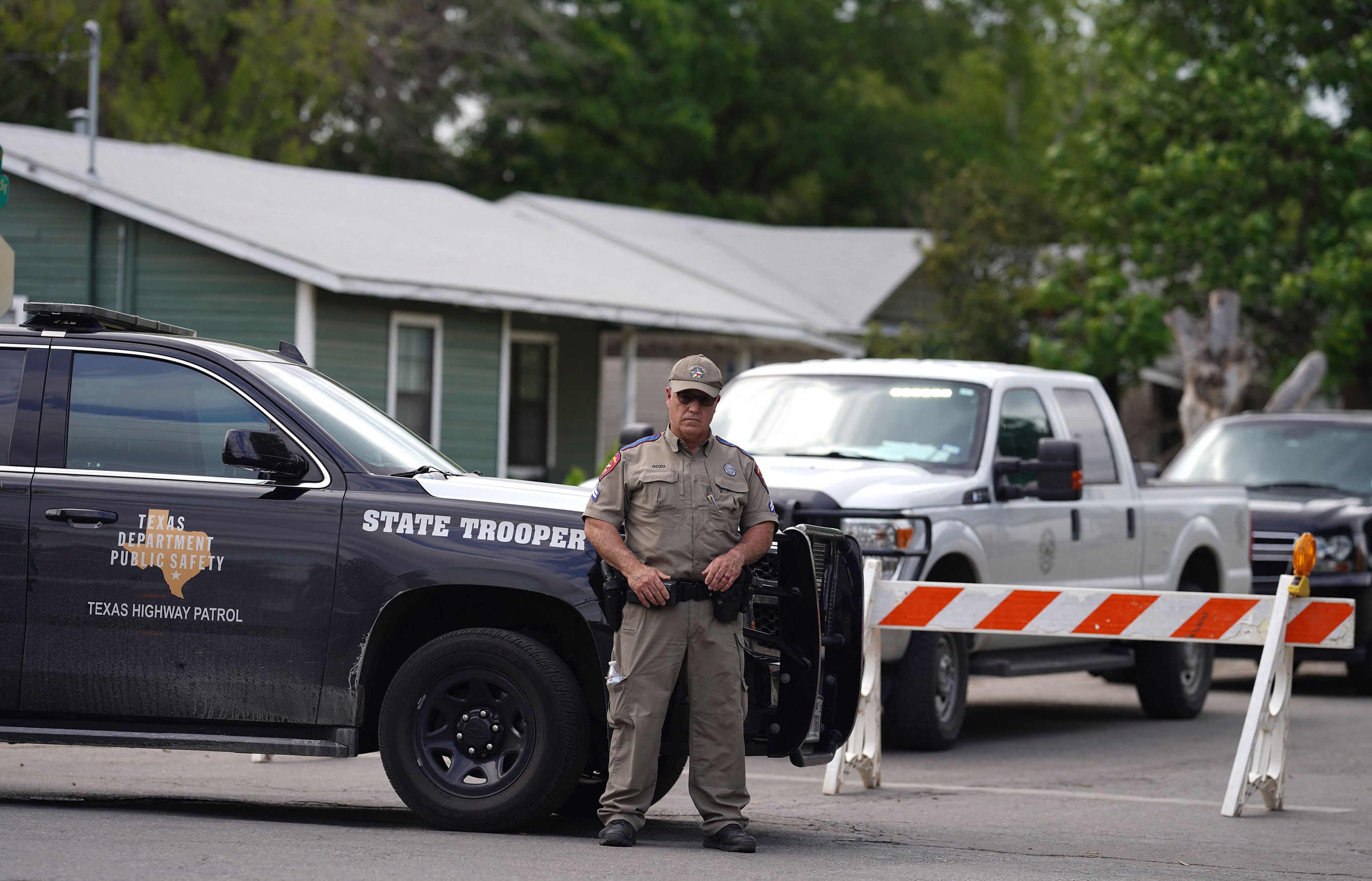 A State trooper stands seen outside of Robb Elementary School in Uvalde, Texas, on Tuesday, May 24, 2022, after an 18-year-old gunman killed 14 children and a teacher at the school. (Allison Dinner/AFP/Getty Images/TNS)