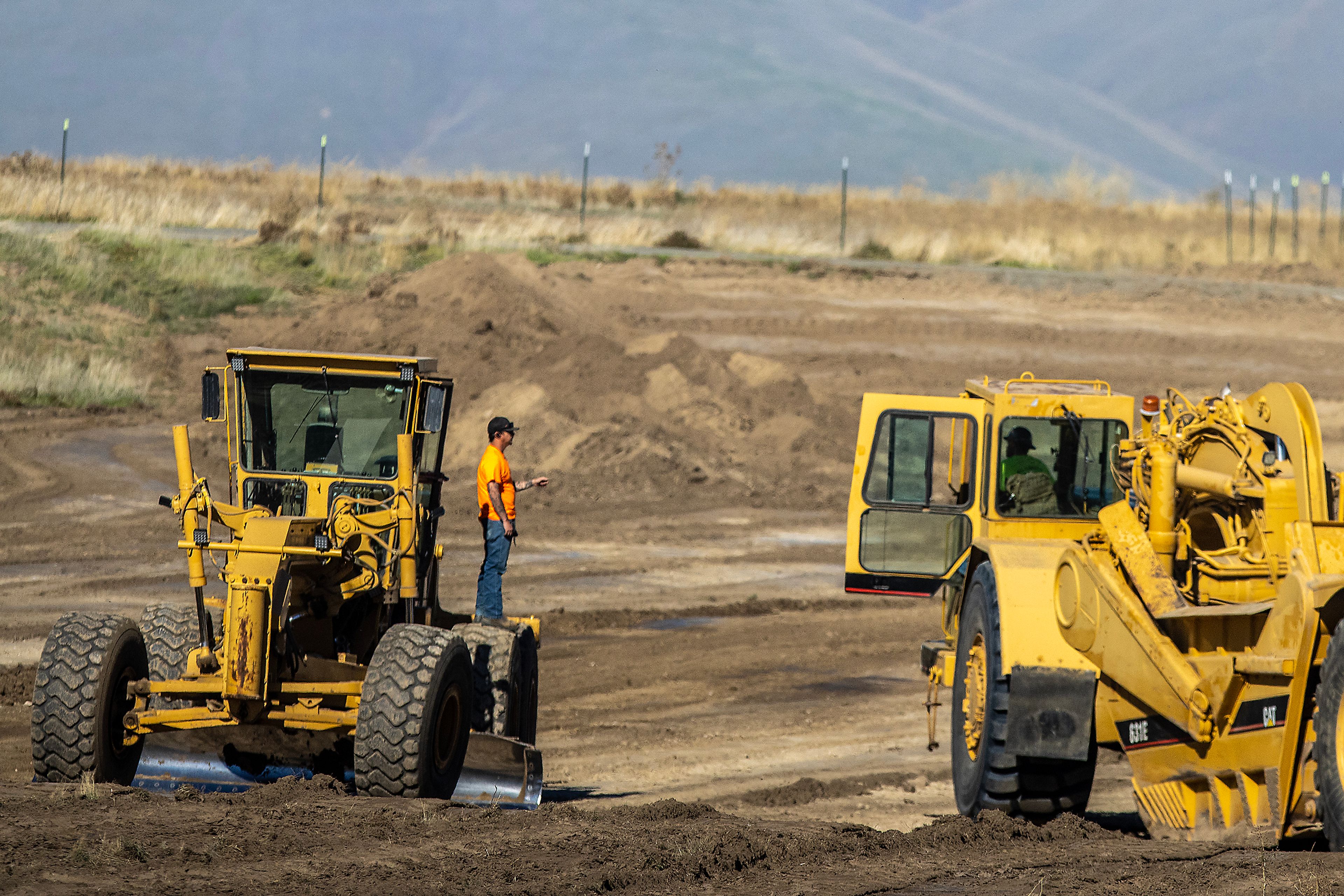 Workers talk Wednesday at the future athletic fields at Lewiston High School.