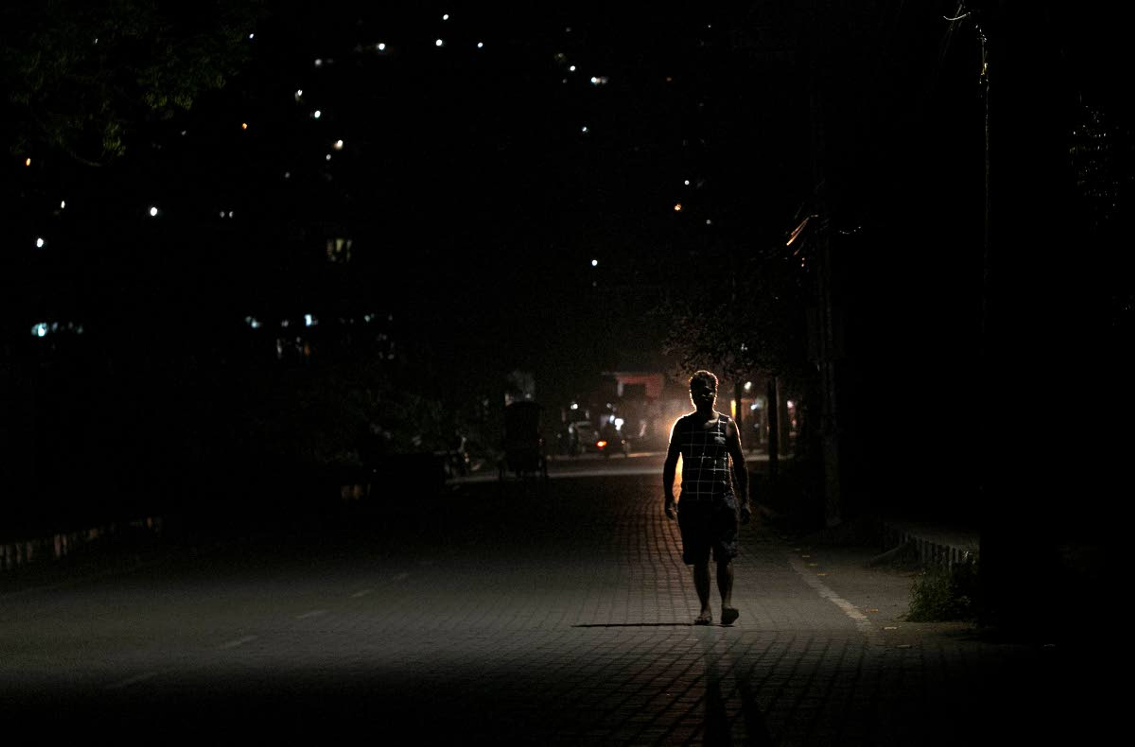 Ramananda Sarkar, 43, returns to his hotel after cremating bodies of COVID-19 victims in Gauhati, India, Tuesday, Sept. 15, 2020. Sarkar, who was deep in debt and desperate for money, took the job of lighting funeral pyres after failing to pay back a loan he'd taken to start selling sugarcane juice on a wooden cart. When his landlord heard about Sarkar's work, he told him he would have to move out. Thankfully a district official arranged a hotel room for him. Sarkar said he alone has cremated more than 450 COVID-19 victims. (AP Photo/Anupam Nath)