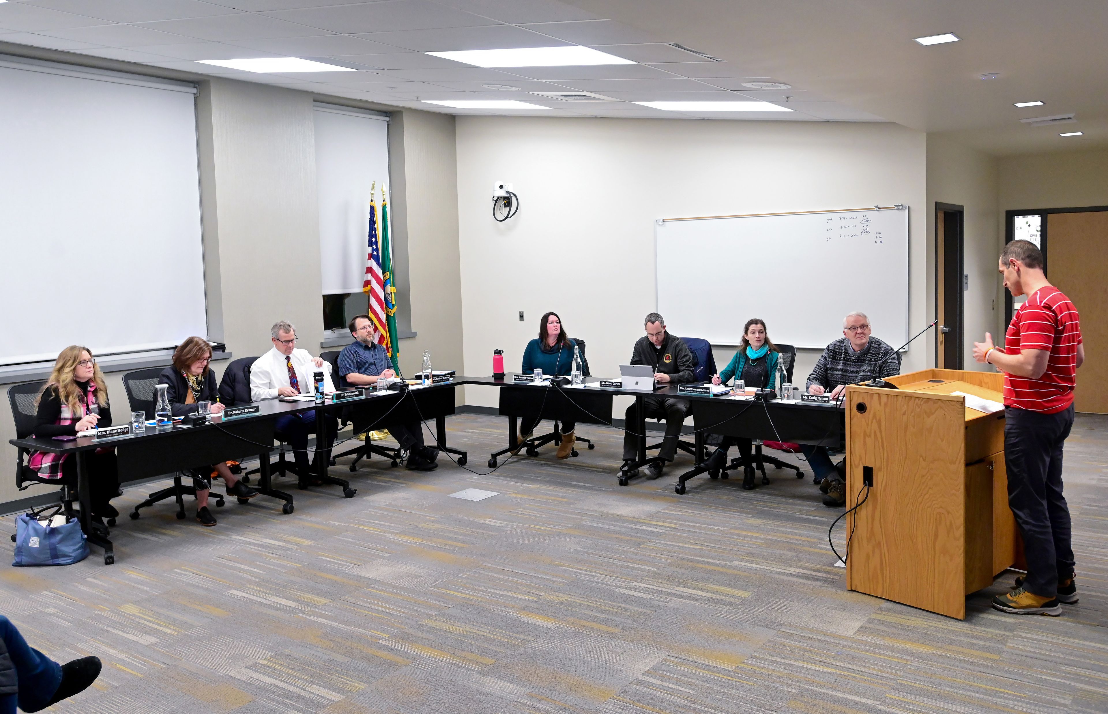 Members of the Pullman Public Schools administration and the Board of Directors listen as Anthony Haynes, right, a fifth grade teacher, speaks during public comment at a meeting on Wednesday.