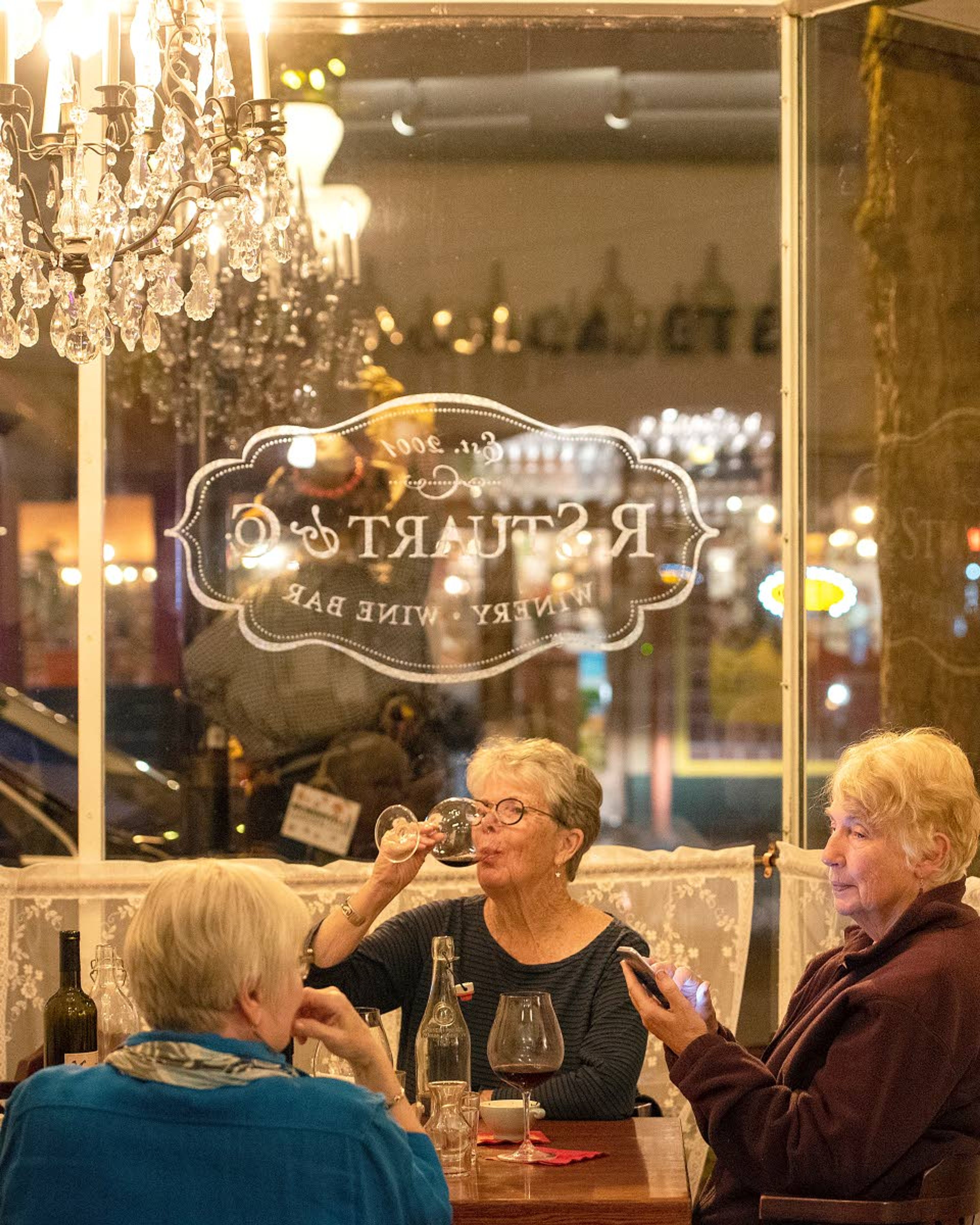 Anne Wall (center), of McMinnville, finishes the last drops of her glass of red wine while spending an evening at R Stuart & Co. Tasting Room & Wine Bar with friends Pam Hoskin (left) and Jan Clay in downtown McMinnville.