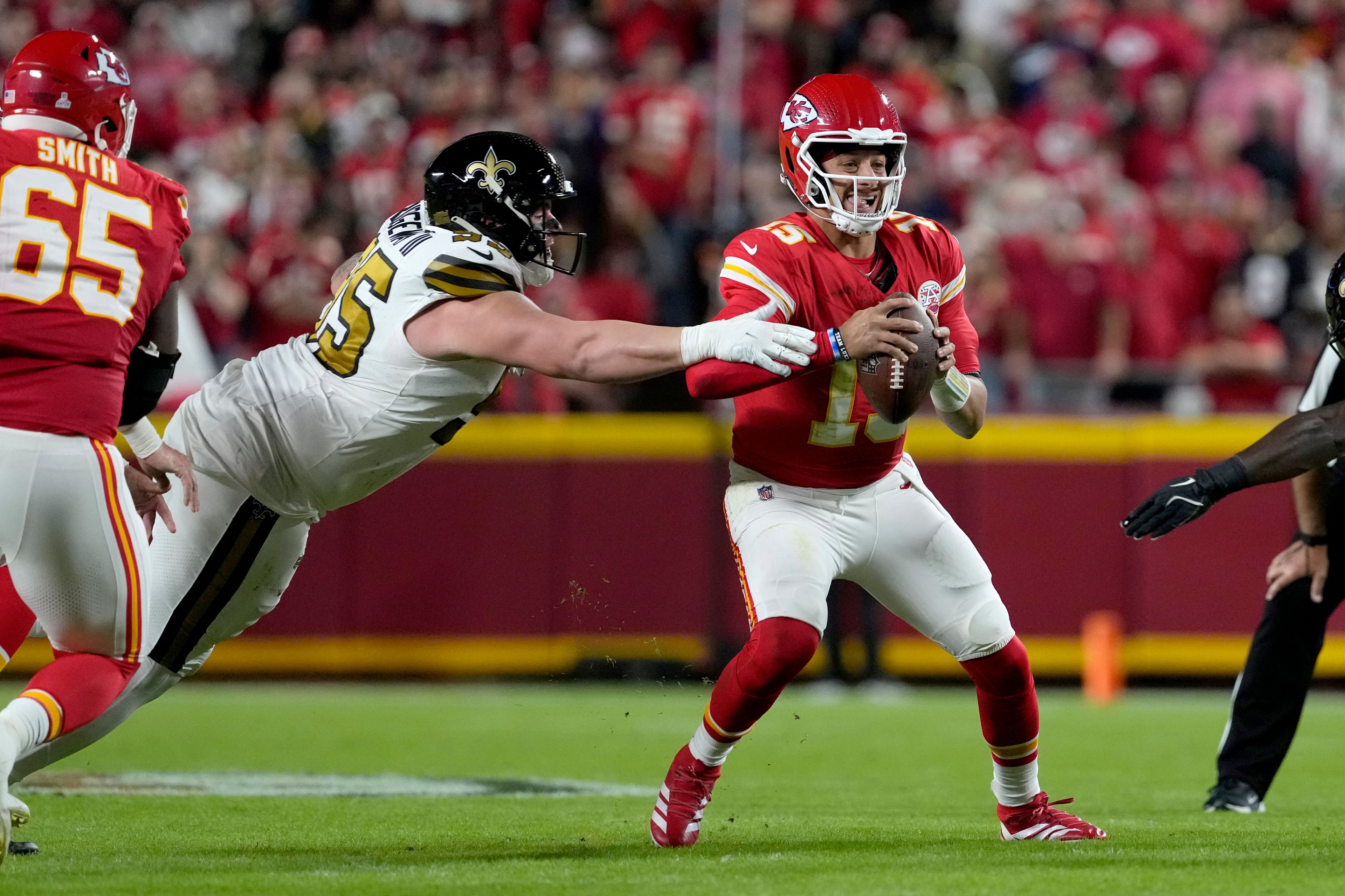 Kansas City Chiefs quarterback Patrick Mahomes, right, scrambles away from New Orleans Saints defensive tackle John Ridgeway III during the first half of an NFL football game Monday, Oct. 7, 2024, in Kansas City, Mo. (AP Photo/Ed Zurga)