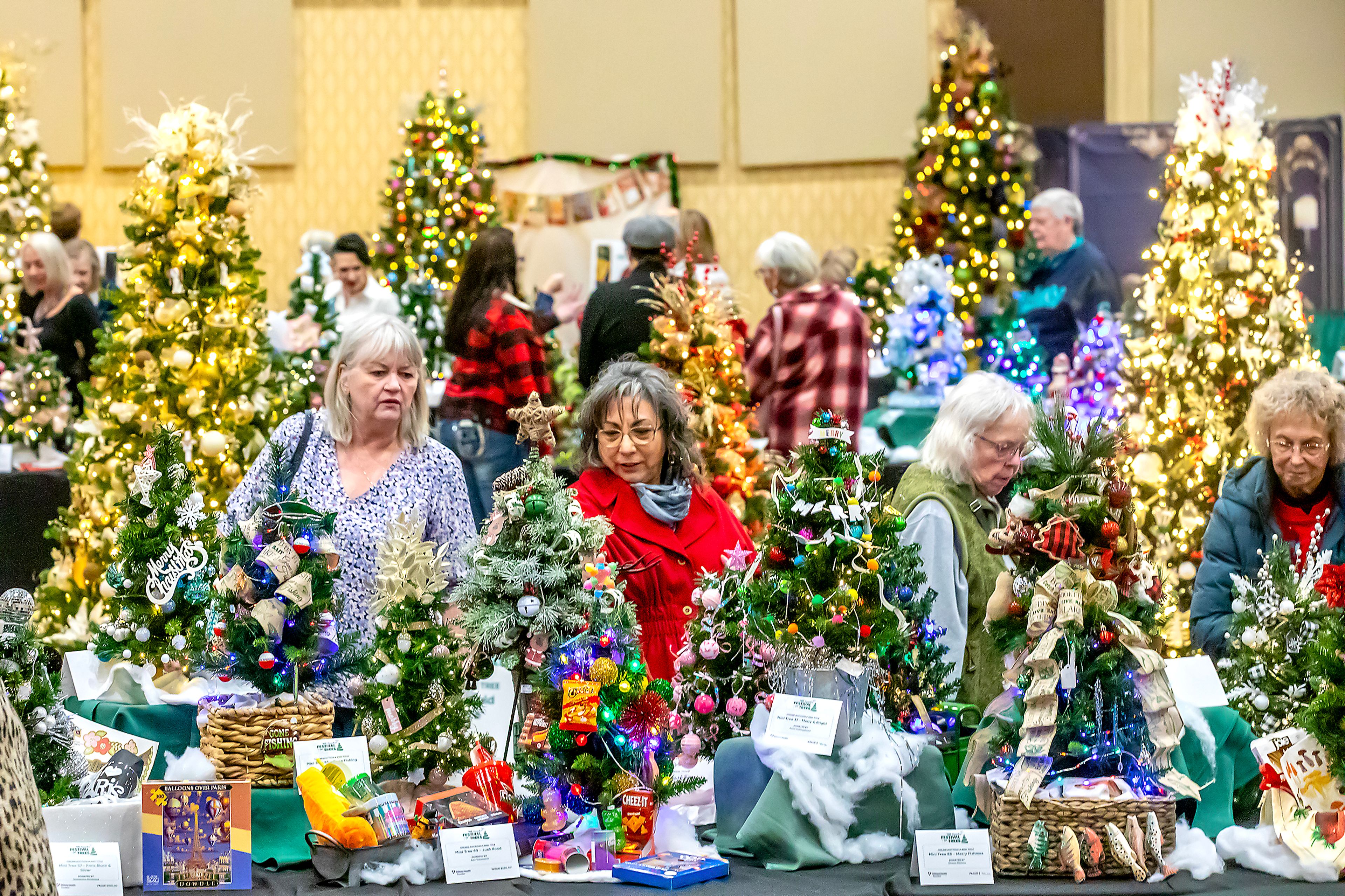 People look over the various trees on display at the 40th annual TriState Health Festival of Trees Friday at the Clearwater River Casino. The event features 88 mini trees, 9 golden groves, 13 large trees, and 21 wreaths.