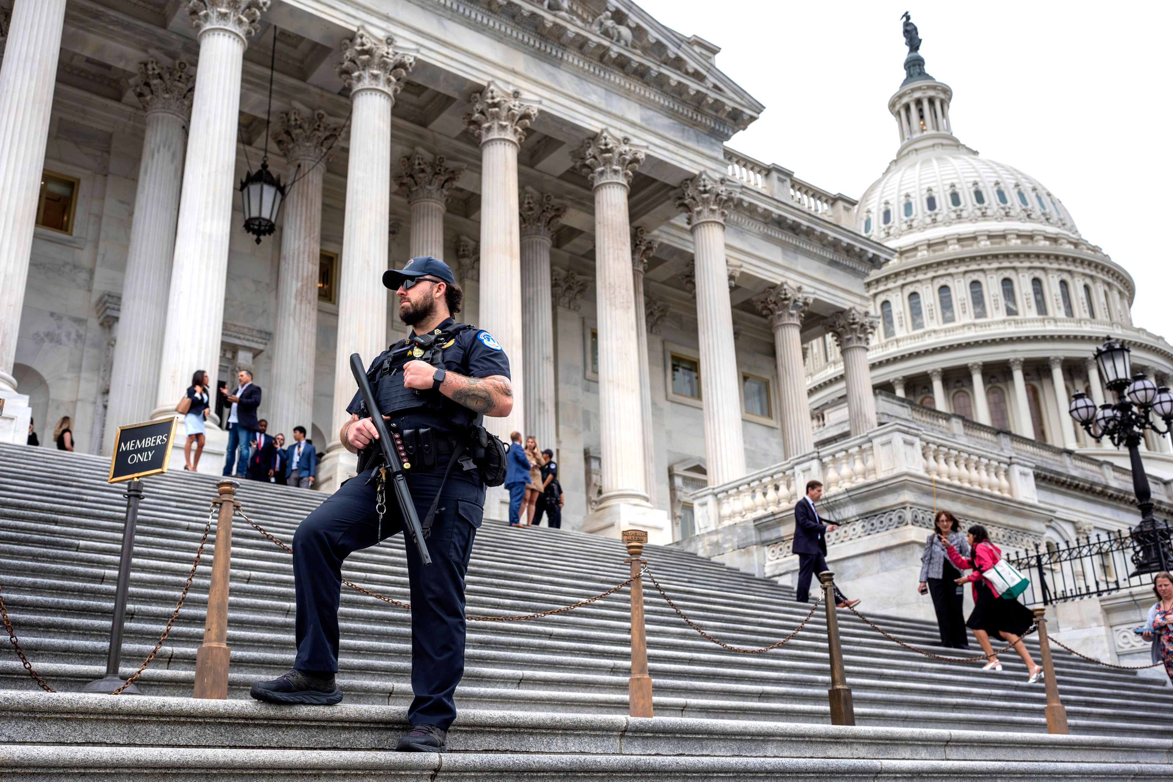 A U.S. Capitol Police officer stands watch as lawmakers leave the House of Representatives after voting on an interim spending bill to avoid a government shutdown next week, at the Capitol in Washington, Wednesday, Sept. 25, 2024. (AP Photo/J. Scott Applewhite)