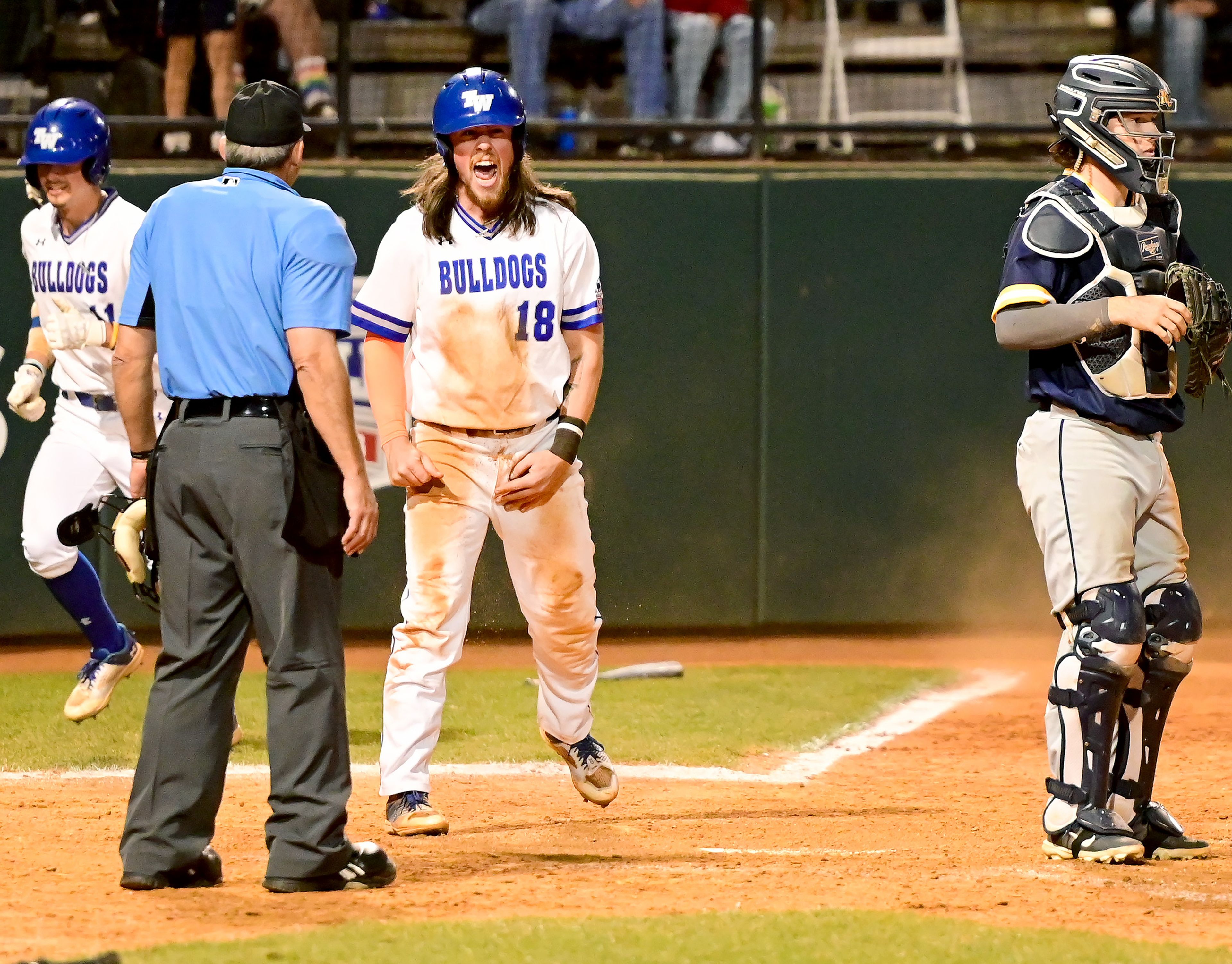 Tennessee Wesleyan’s Evan Magill celebrates a second slide into home plate in Game 18 of the NAIA World Series against Reinhardt at Harris Field in Lewiston on Thursday.