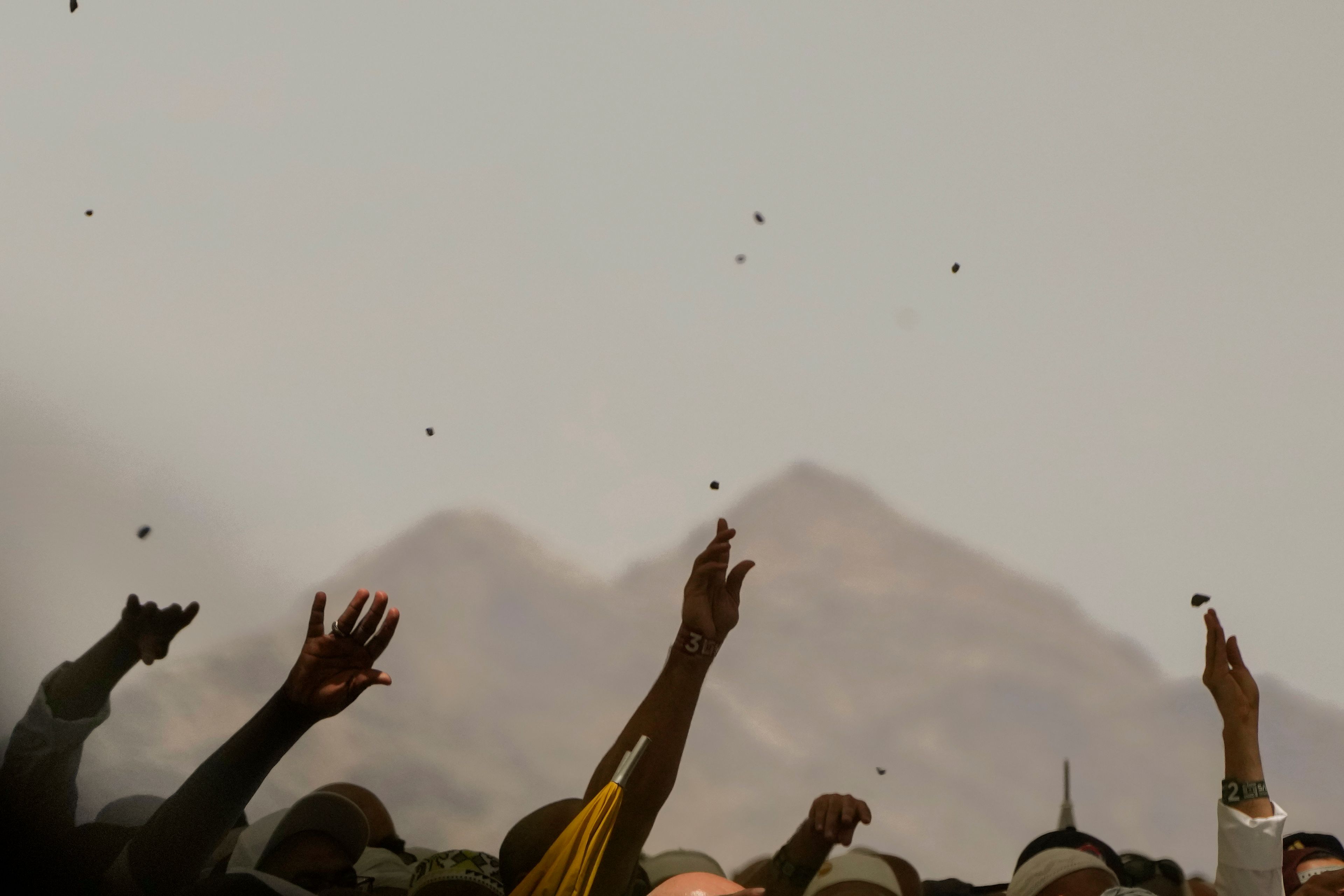 FILE - Muslim pilgrims cast stones at pillars in the symbolic stoning of the devil during the annual Hajj, in Mina near the holy city of Mecca, Saudi Arabia, on June 30, 2023. Once a year, Muslim pilgrims coming to Saudi Arabia from around the world unite in a series of religious rituals and acts of worshipping God as they perform Hajj, one of the pillars of Islam. Among other rituals, pilgrims throw pebbles in a symbolic stoning of the devil.