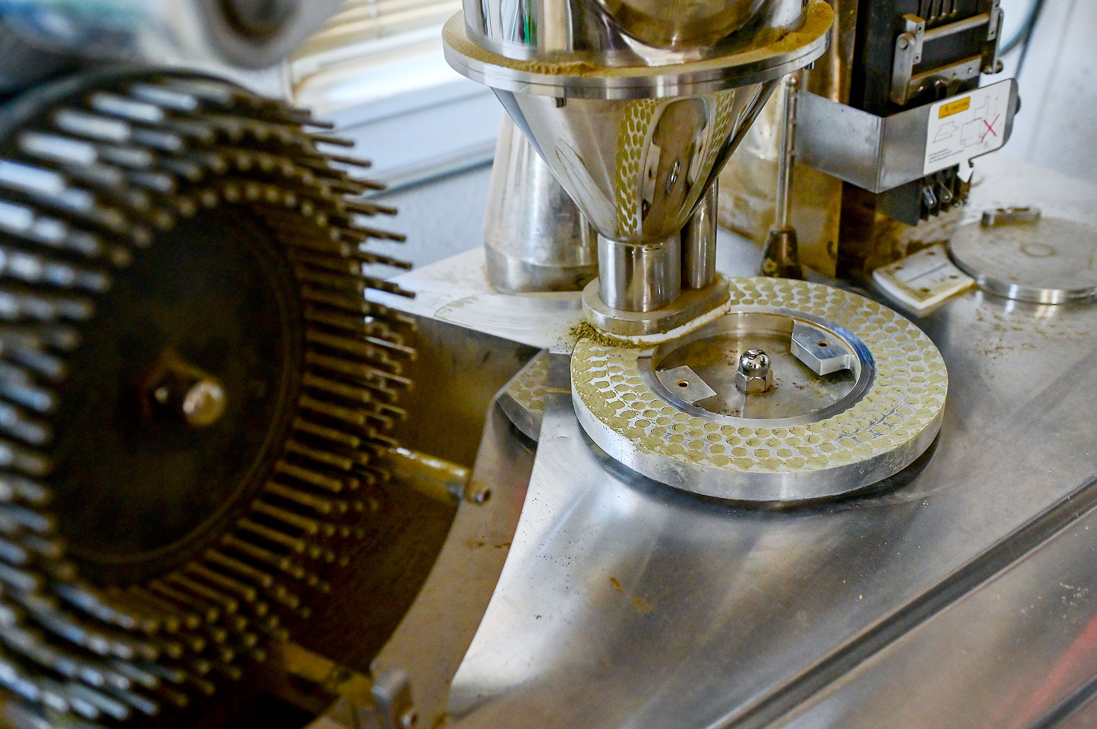 A machine is used to fill capsules with kratom powder Friday at Kratom Kings in Moscow.
