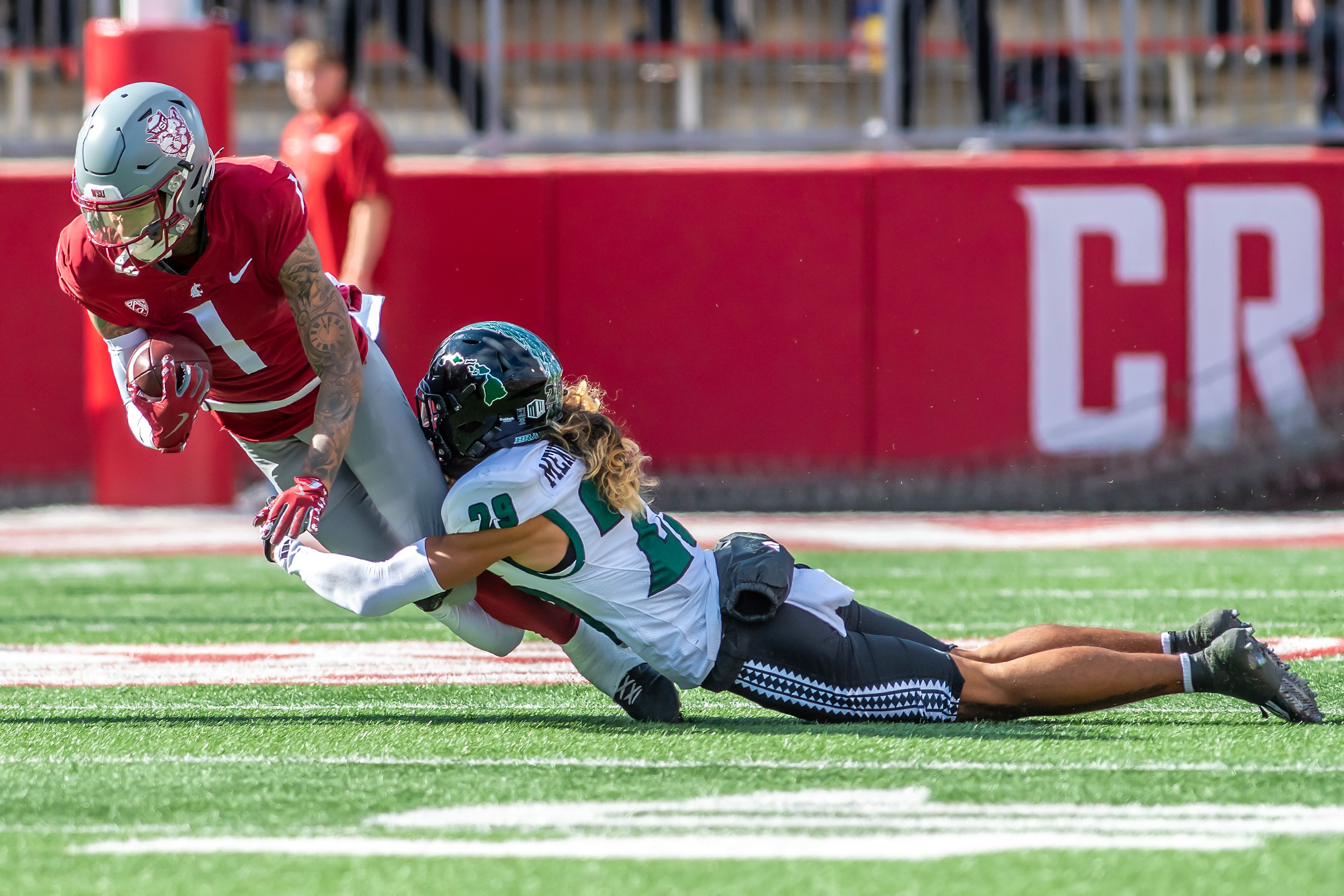 Washington State wide receiver Kris Hutson is tackled by Hawaii defensive lineman Vaifanua Peko in a college football game on Saturday at Gesa Field in Pullman.,