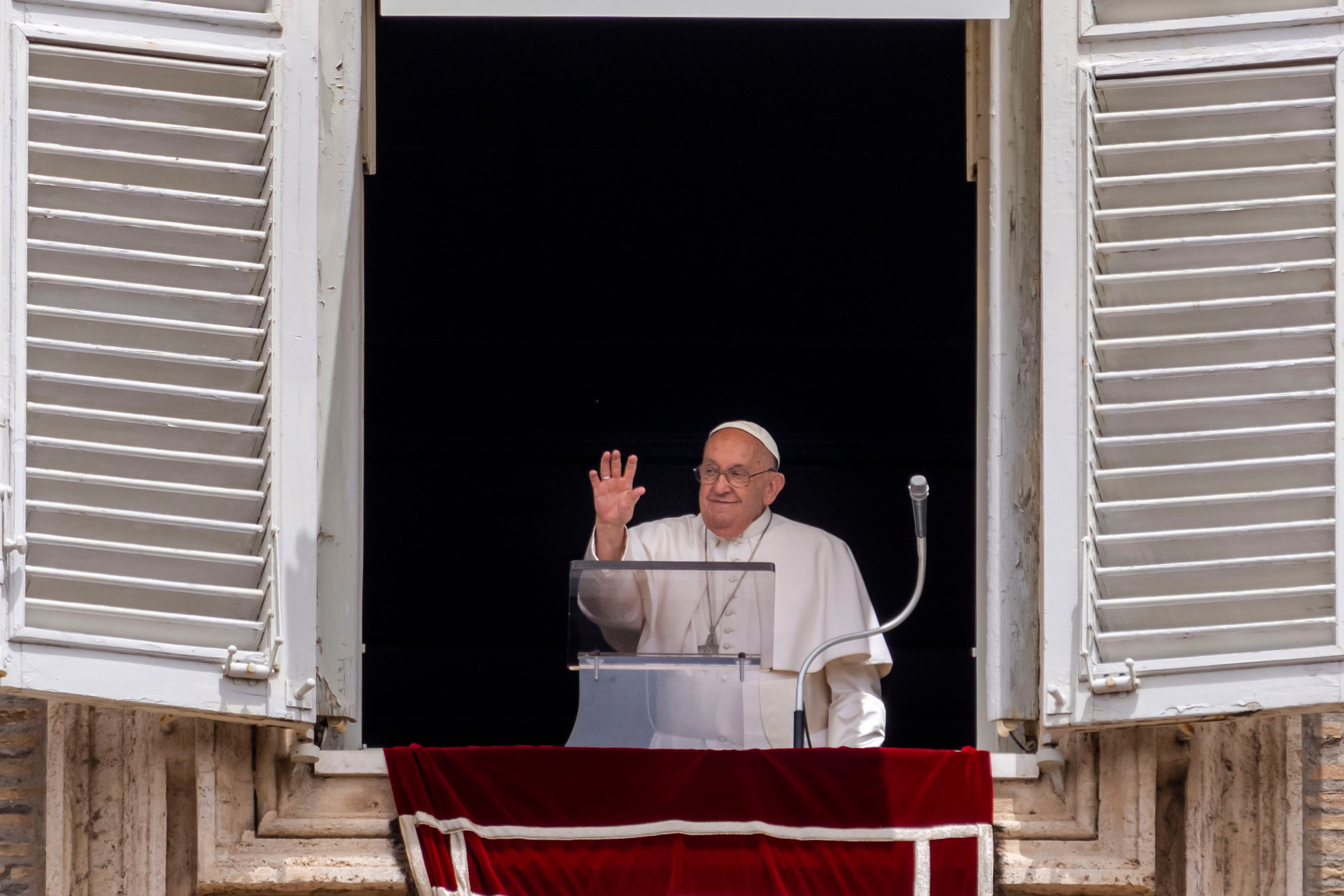 Pope Francis waves from his studiio's window overlooking St. Peter's Square at The Vatican, Sunday, June 9, 2024, where faithful and pilgrims gathered for the traditional Sunday's blessing at the end of the Angelus prayer.