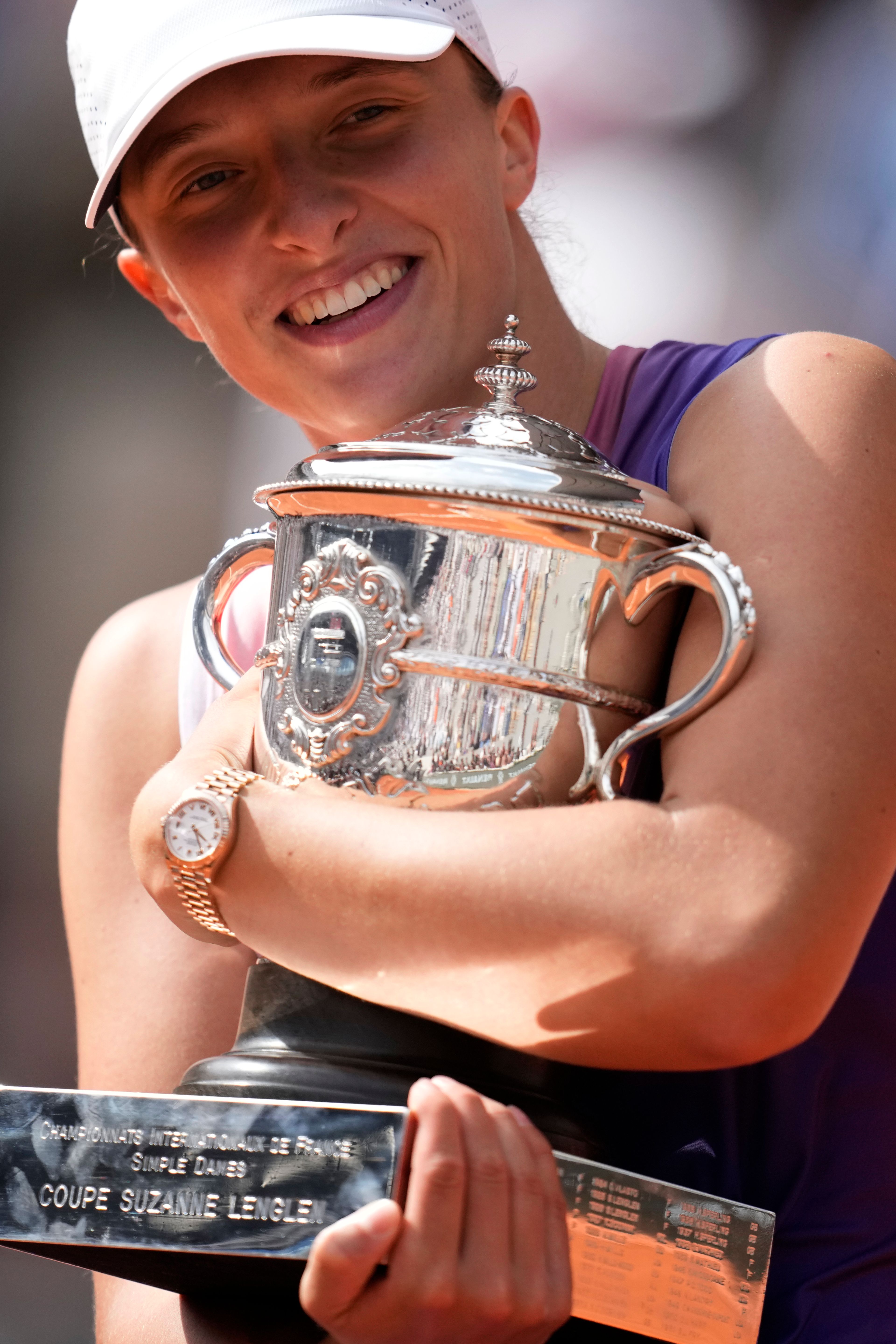 Poland's Iga Swiatek celebrates with the trophy as she won the women's final of the French Open tennis tournament against Italy's Jasmine Paolini at the Roland Garros stadium in Paris, France, Saturday, June 8, 2024.