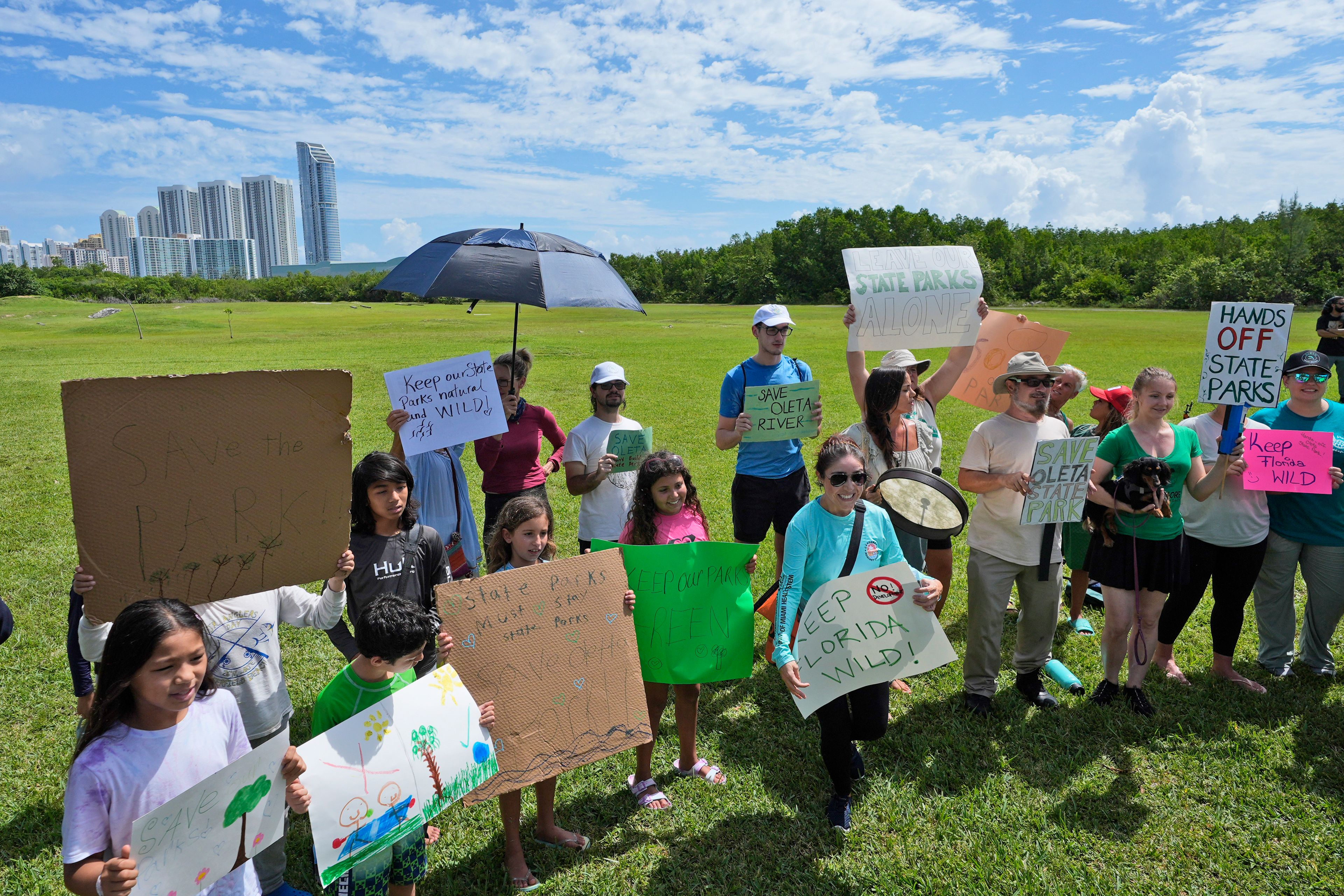 Demonstrators chant during a protest against Gov. Ron DeSantis' plan to develop state parks with business ventures such as golf courses, pickleball courts and large hotels, at Oleta River State Park, Tuesday, Aug. 27, 2024, in North Miami Beach, Fla.